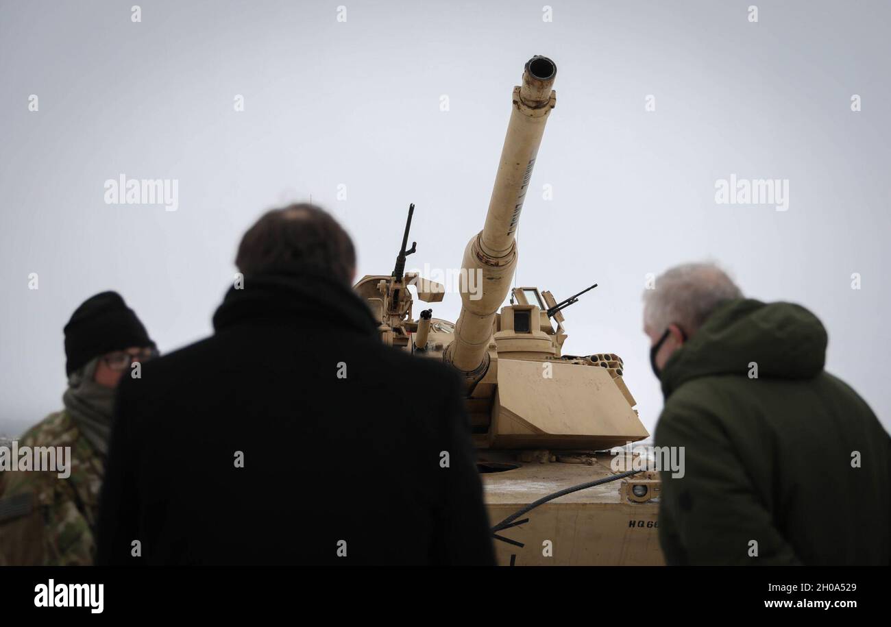 Der US-Botschafter in Litauen, Robert Gilchrist, links, und der litauische Verteidigungsminister Arvydas Anusaukas, rechts, stellen nach einer Zeremonie zur Enthüllung der Farbe Fragen an ein Mitglied der M1 Abrams Panzerbesatzung am 4. Januar 2021. Die Zeremonie bedeutet offiziell die Ankunft des 2. Bataillons, des 8. Kavallerieregiments, des 1. Kampfteams der Panzerbrigade und der 1. Kavalleriedivision im Pabrade-Trainingsgebiet in Litauen. Stockfoto