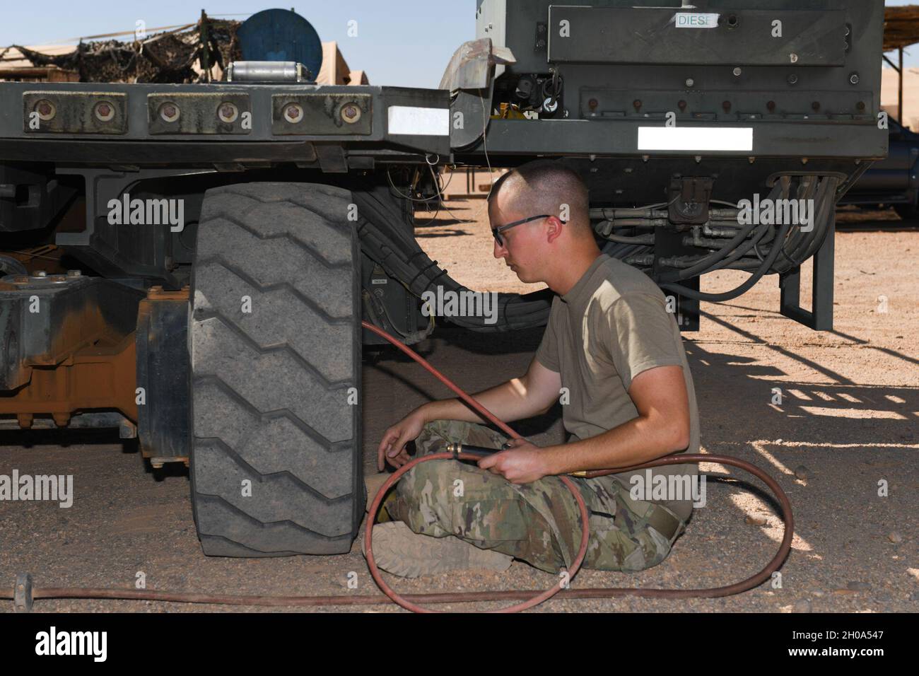 Ryan Davis, Senior Airman der US Air Force, 724. Mitarbeiter des Operations Center des Expeditionary Air Base Squadron, legt Luft in einen Halvorsen 25K-Loader-Reifen, auf dem Nigerien Air Base 201, Agadez, Niger, 4. Januar 2021. Diese Maschinen werden zum hoch- und Herunterladen von Paletten, Palettenzügen und Rollmaterial in Frachtflugzeugen verwendet. Stockfoto