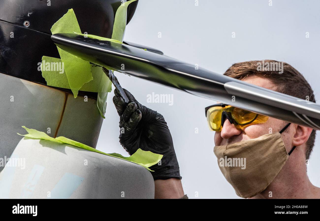 US Air Force Tech. Sgt. Ryan Gladu, ein Handwerker für die Flugzeugstrukturwartung mit dem 1. Special Operations Aircraft Maintenance Squadron, bringt Dichtmittel auf, um die Klinge an einem Tiltrotor-Flugzeugmodell CV-22B von Osprey in Hurlburt Field, Florida, am 6. Januar 2021, wieder anzubringen. Die Air Commandos wendeten ihre Wartungskompetenz auf die Reparatur des Osprey-Modells an, das während des Orkandels Sally im September 2020 beschädigt wurde. Stockfoto
