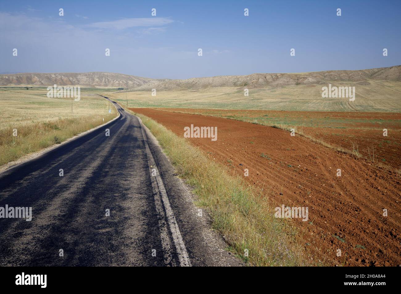 Landschaft der zentralanatolischen Region in der Türkei Straße kreuzt Steppe mit gepflügten Feld und Grasland Stockfoto