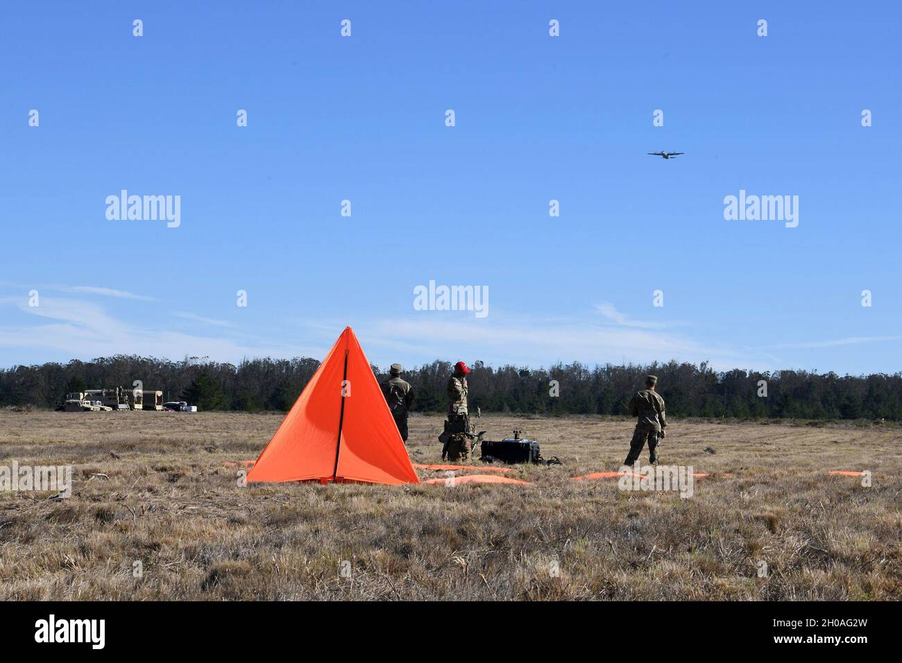 Soldaten, die der 346. Theatre Aerial Delivery Company, einer Luftwaffeneinheit der Armee auf der Joint Forces Training Base Los Alamitos, Kalifornien, zugewiesen wurden, sprechen mit der Luftbesatzung auf einer Hercules C-130 während eines taktischen, flachen, statischen Einführungstrainings für Fallschirme am 9. Januar 2021 auf der Vandenberg Air Force Base, Calif. Dieses 346. TADC nutzte die Vandenberg AFB Drop Zone, um das Training durchzuführen, um die Qualifikationen zu erhalten, die für ihre Mission einzigartig sind. Stockfoto