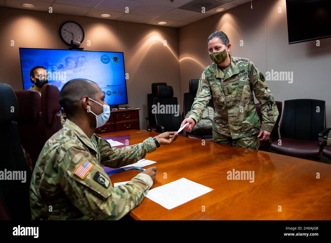 LT. General Jody Daniels (rechts), Chef der Army Reserve und kommandierender General, U.S. Army Reserve Command, erhält eine Krankenkarte als Nachweis für ihre COVID-19-Impfung im Womack Army Medical Center in Fort Bragg, North Carolina, 11. Januar 2021. Die Pfizer- und Moderna-Impfstoffe verwenden transiente Informationstrangemoleküle (mRNA), um unseren Zellen beizubringen, ein Protein herzustellen, das die Antikörperbildung auslöst, um eine Immunantwort in unserem Körper zu erzeugen. Die mRNA ist synthetisch, nicht aus echten Viren extrahiert, und sie tritt nicht in die körpereigene DNA ein oder interagiert nicht mit ihr. Der Impfstoff erfordert zwei d Stockfoto