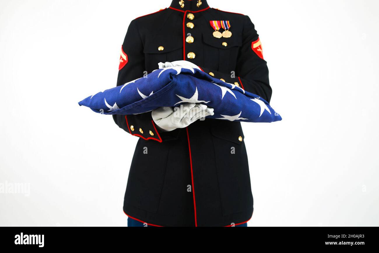 US Marine Lanze CPL. Zachary Shull, detaillierter Kommandant mit Zeremonialzug, Marineporps-Basis Quantico, VA., steht mit gefalteter Flagge. Die gefaltete Flagge soll den ursprünglichen 13 Kolonien und denen, die gedient haben, Tribut zollen. Stockfoto