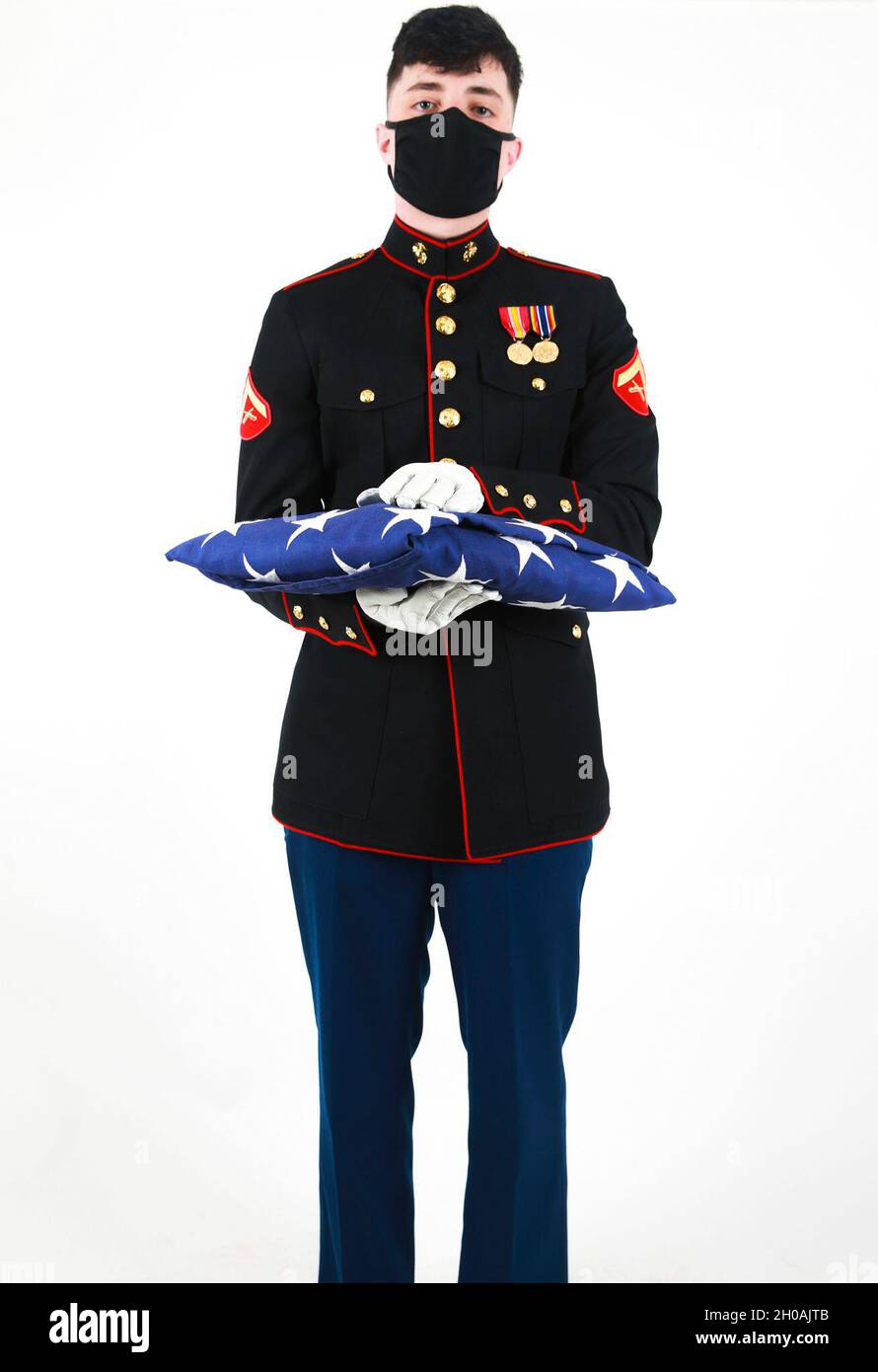 US Marine Lanze CPL. Zachary Shull, detaillierter Kommandant mit Zeremonialzug, Marineporps-Basis Quantico, VA., steht mit gefalteter Flagge. Die gefaltete Flagge soll den ursprünglichen 13 Kolonien und denen, die gedient haben, Tribut zollen. Stockfoto