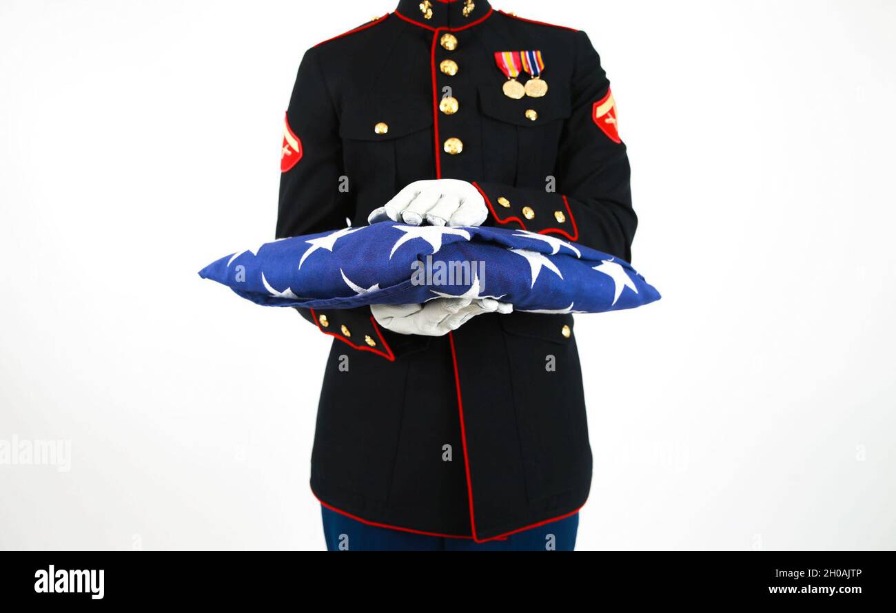 US Marine Lanze CPL. Zachary Shull, detaillierter Kommandant mit Zeremonialzug, Marineporps-Basis Quantico, VA., steht mit gefalteter Flagge. Die gefaltete Flagge soll den ursprünglichen 13 Kolonien und denen, die gedient haben, Tribut zollen. Stockfoto