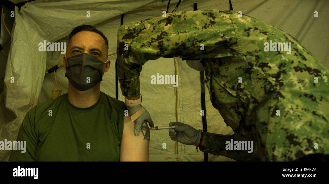 US Marine Corps Gunnery Sgt. Steven Cushman, Leiter Kommunikationsstrategie und Operationen bei der 3d Marine Division, erhält die COVID-19-Impfung im US Naval Hospital Okinawa auf Camp Foster, 12. Januar 2021. Dieser Impfstoff wurde entwickelt, um Antikörper zu erzeugen, die den Empfänger vor COVID-19 schützen und die Ausbreitung des Virus bekämpfen. Marineinfanteristen und Matrosen erhielten freiwillig die Impfung, um andere zu schützen und sicherzustellen, dass die 3d Marine Division jetzt kampfbereit bleibt. Cushman stammt aus Olympia, Washington. Stockfoto