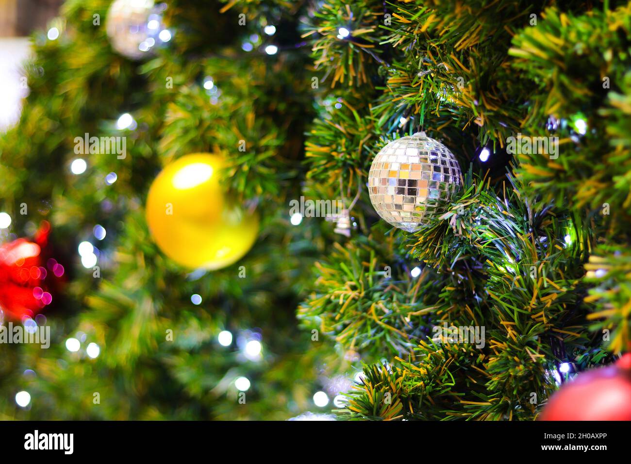 Weihnachtsbaum mit elektrischem Licht und bunten Kugeln verziert. Geeignet als Kulisse für Weihnachten und Neujahr. Stockfoto