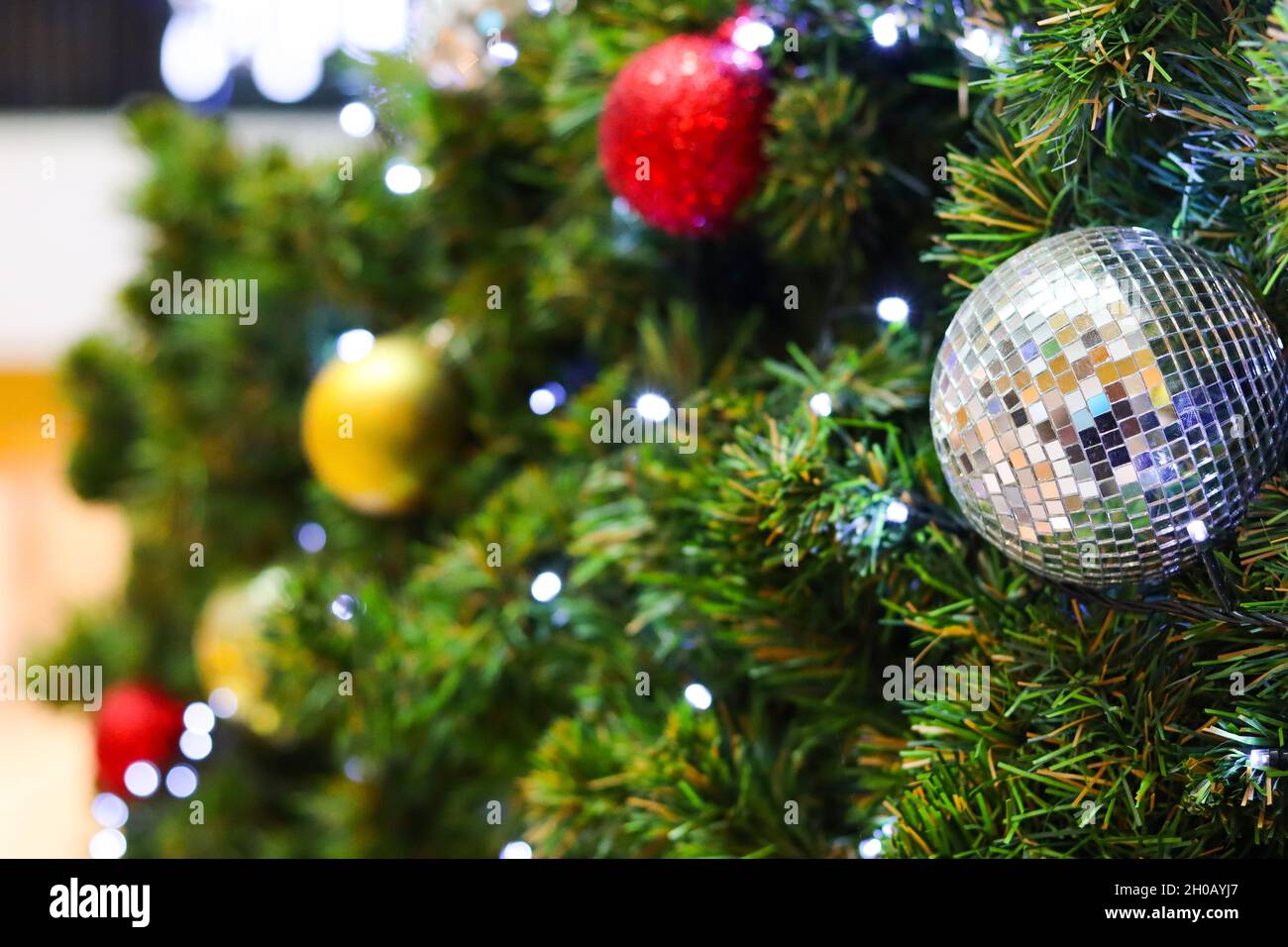 Weihnachtsbaum mit elektrischem Licht und bunten Kugeln verziert. Geeignet als Kulisse für Weihnachten und Neujahr. Stockfoto