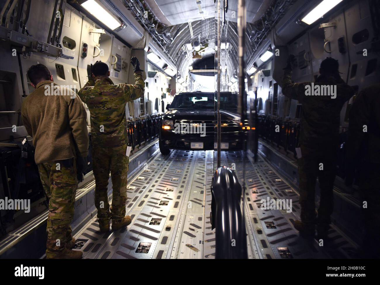 US Air Force Staff Sgt. Peter Simpson und Airman Addison Hart, Ladermeister der 6th Airlift Squadron, laden ein Vice Presidential Vehicle auf einen C-17 Globemaster III aus dem 305th Air Mobility Wing, der der Joint Base McGuire-Dix-Lakehurst, N.J., am 14. Januar 2021, auf der Joint Base Andrews, Maryland, zugewiesen wurde. Vizepräsident Mike Pence wird an der Gedenkfeier für den pensionierten General Charles E. „Chuck“ Yeager teilnehmen. Yeager war 97 Jahre alt, als er starb. Stockfoto