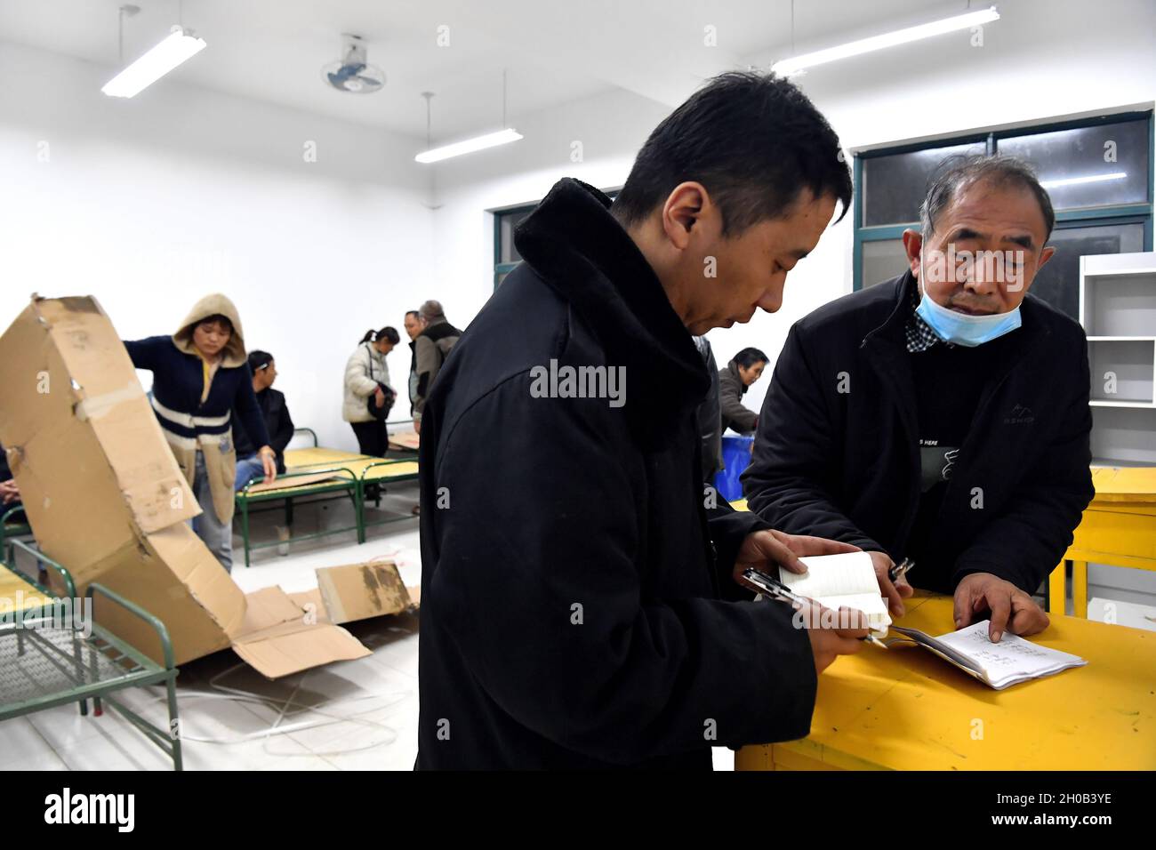 Dali, Chinas Provinz Shaanxi. Oktober 2021. Bewohner, die von der Flut betroffen sind, registrieren sich am 11. Oktober 2021 an einem vorübergehenden Umzugsort im Landkreis Dali in der Stadt Weinan, nordwestlich der chinesischen Provinz Shaanxi. Fast 240,000 Menschen waren von den Überschwemmungen infolge kontinuierlicher Regengüsse im Landkreis Dali der Provinz Shaanxi betroffen. Bisher wurden mehr als 25,000 Menschen auf temporäre Umzugsorte evakuiert, die Unterkünfte und medizinische Versorgung anbieten. Quelle: Liu Xiao/Xinhua/Alamy Live News Stockfoto