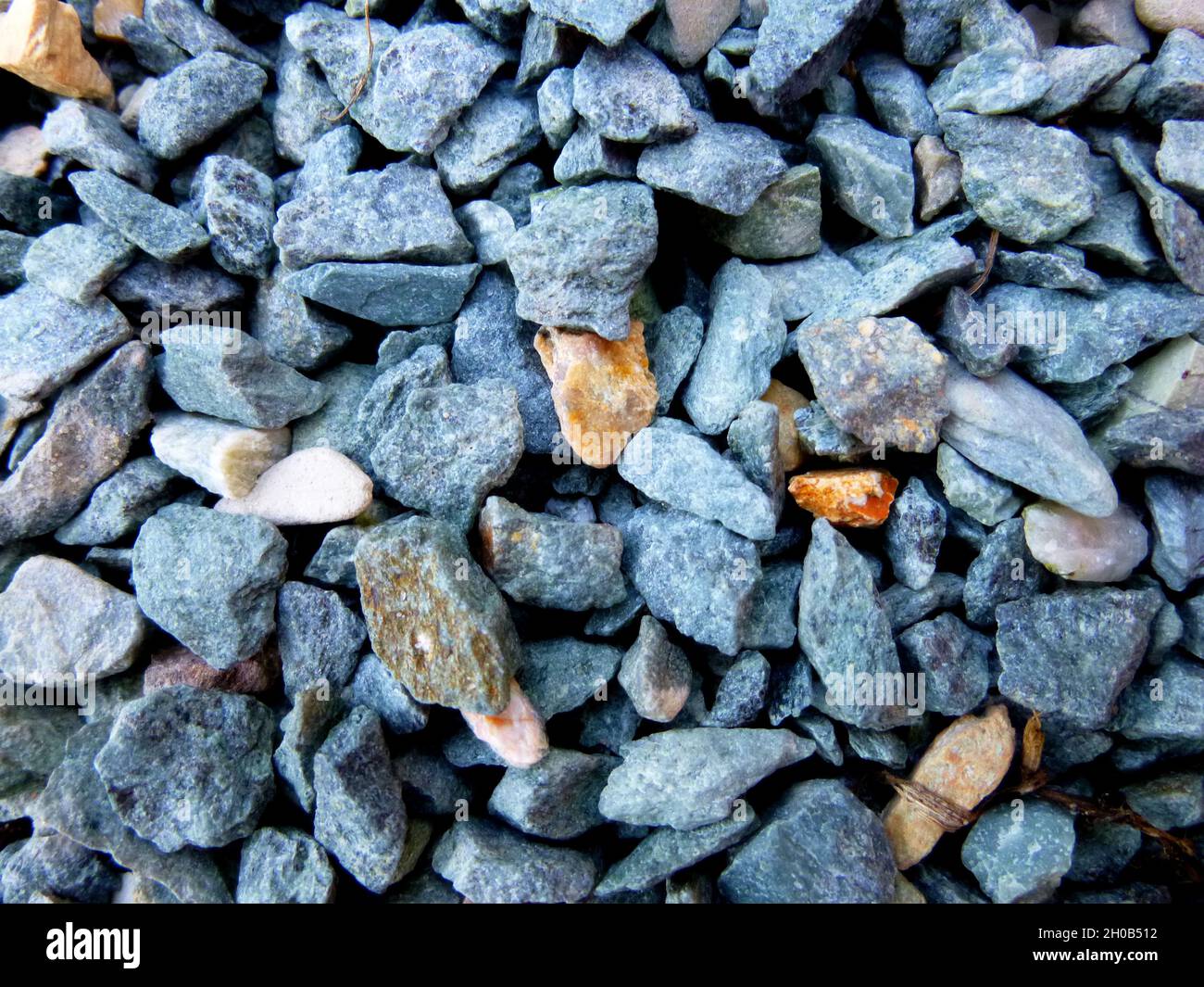 Grauer Boden Steinschutt Hintergrund von vielen kleinen Steinen. Stockfoto