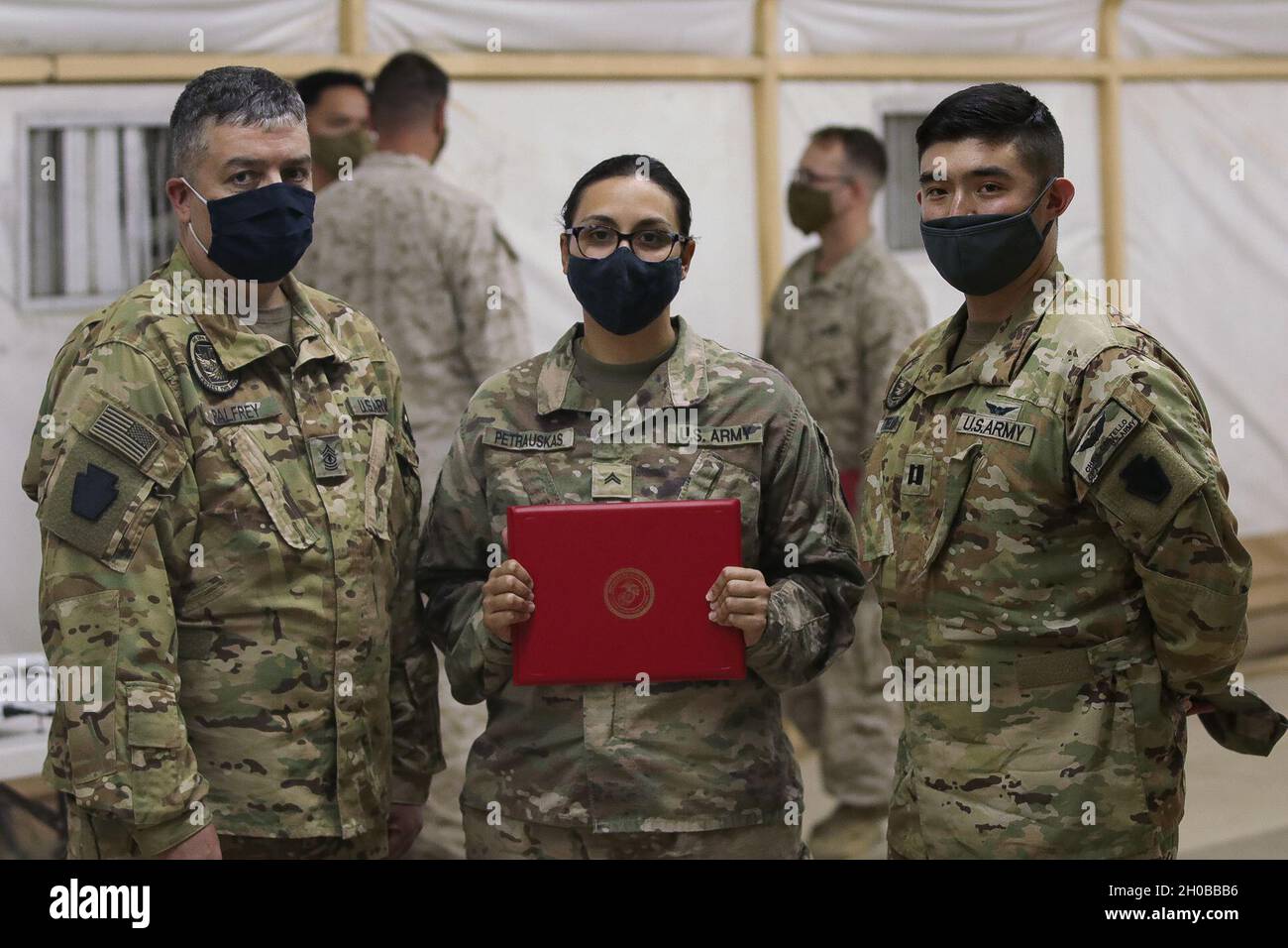 US Army CPL. Courtney Petrauskas, Spezialist für Informationstechnologie bei Headquarters & Headquarters Company, 28th Expeditionary Combat Aviation Brigade, nimmt am 17. Januar 2020 im Nahen Osten eine Auszeichnung des United States Marine Corporal Course entgegen. US-Armeekapt Christopher Costello und 1. Sgt. Frank Palfrey war anwesend. Stockfoto