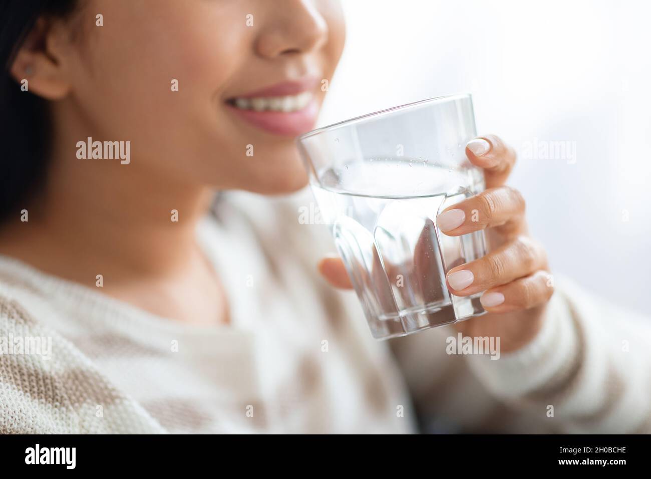 Hydratationskonzept. Nahaufnahme Aufnahme Einer Lächelnden Jungen Dame, Die Wasser Aus Glas Trinkt Stockfoto