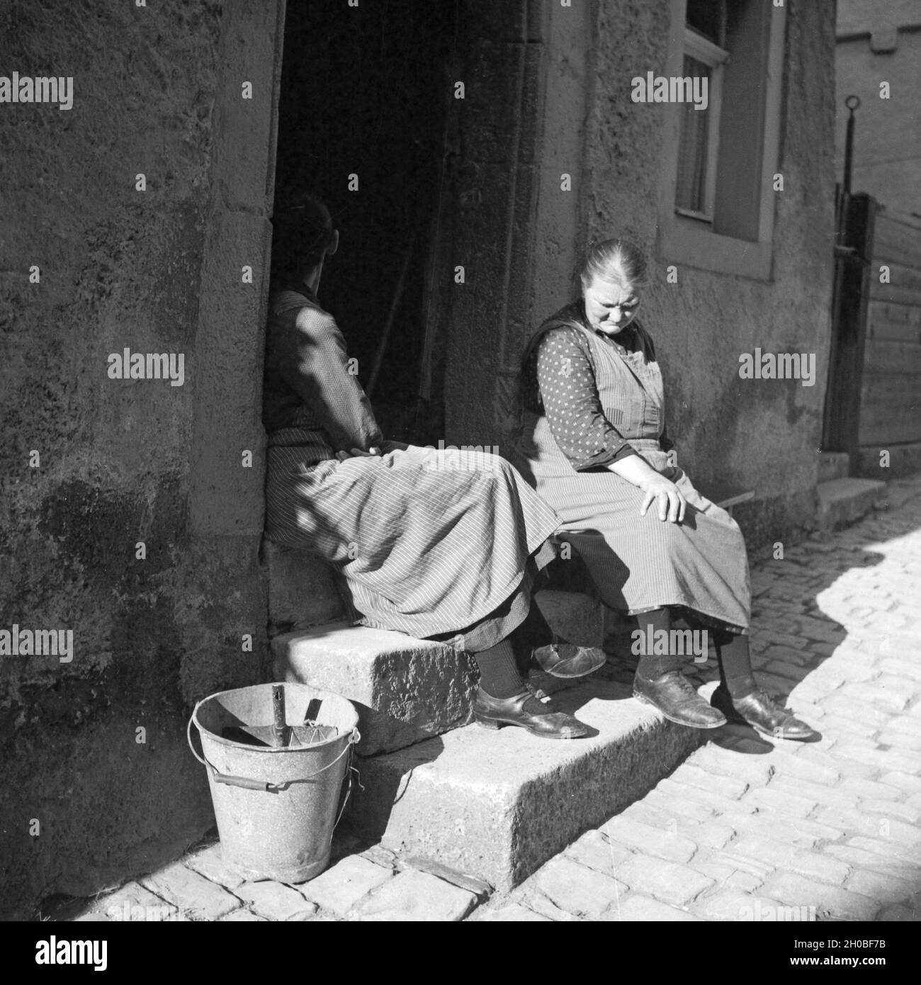 Frauen aus der Ravary einer Bei Einem Schwätzchen Beisammen in Einer Gasse von Rothenburg Ob der Tauber, Deutschland, 1930er Jahre. Frauen aus der Nachbarschaft im Chat in einer Gasse von Rothenburg Ob der Tauber, Deutschland der 1930er Jahre. Stockfoto