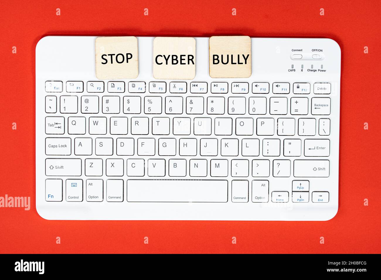 Layout einer Tastatur und Holzfliesen mit Texten STOPPEN CYBER-SCHLÄGER. Cybermobbing-Konzept Stockfoto