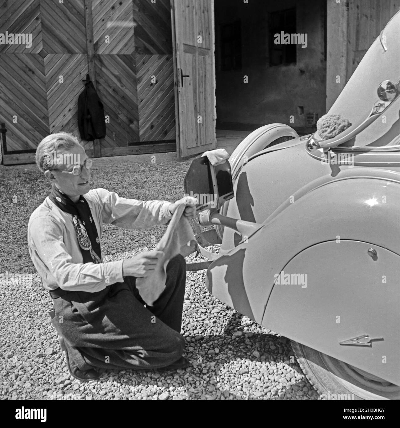 Ein Mann beim Wagenwaschen, Deutschland 1930er Jahre. Ein Mann, der das Auto wascht, Deutschland in den 1930er Jahren. Stockfoto