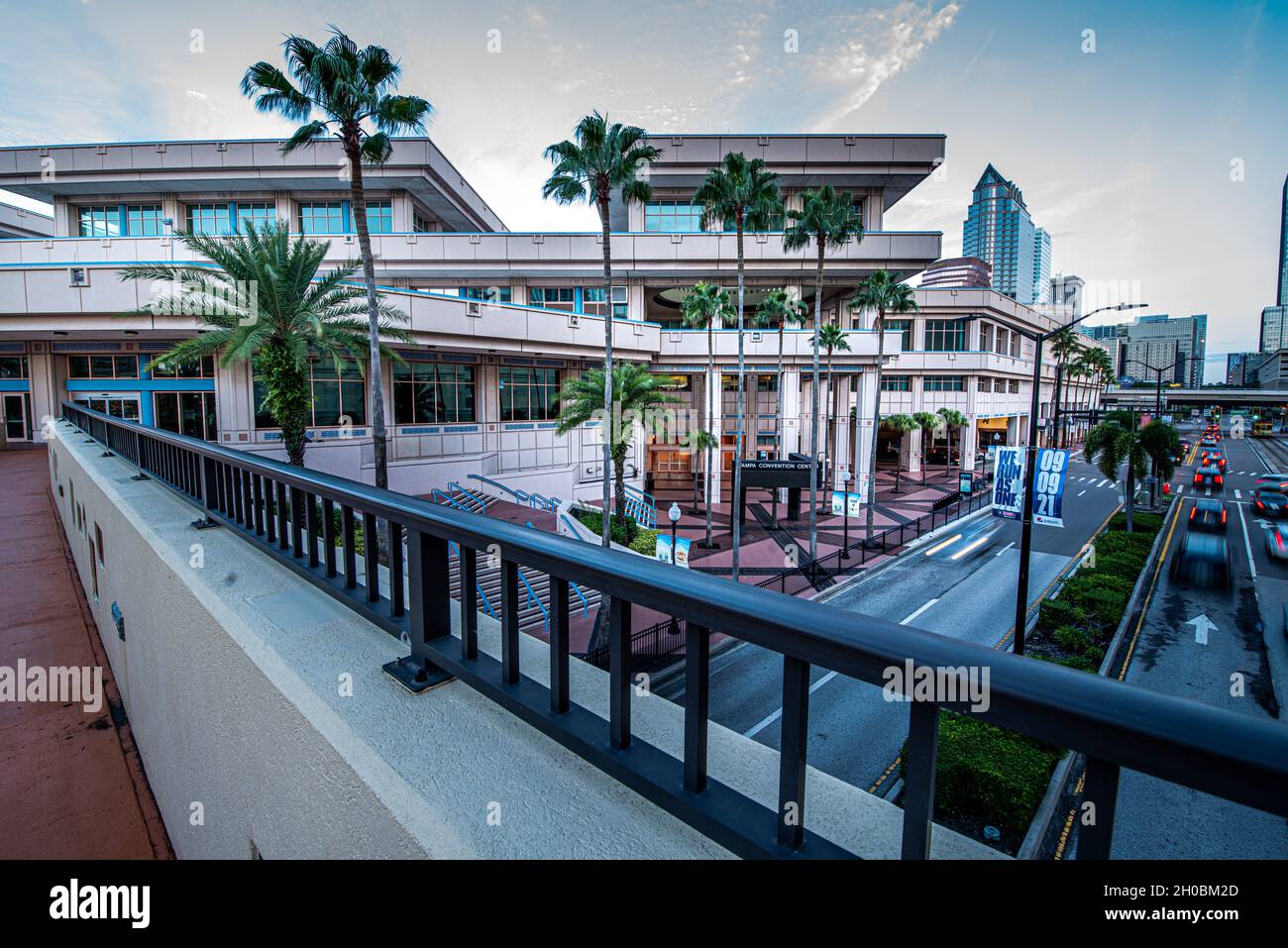 Tampa. FL – 12. September 2021; der Verkehr am frühen Morgen unterquert eine Fußgängerbrücke in der Innenstadt, die mit dem Tampa Convention Center und der Skyline im Hintergrund verbunden ist Stockfoto