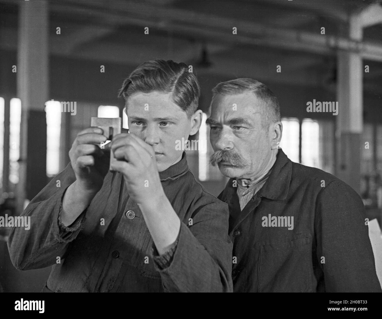 Arbeiter in einer Fabrikhalle bei Mercedes Benz in Stuttgart, Deutschland 1930er Jahre. Arbeiter in einer Werkshalle bei Mercedes Benz in Stuttgart, 1930er Jahre. Stockfoto