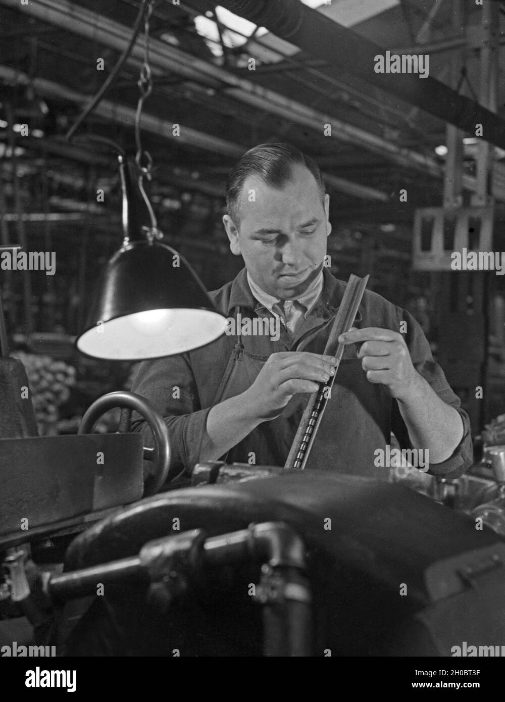 Arbeiter in einer Fabrikhalle bei Mercedes Benz in Stuttgart, Deutschland 1930er Jahre. Arbeiter in einer Werkshalle bei Mercedes Benz in Stuttgart, 1930er Jahre. Stockfoto