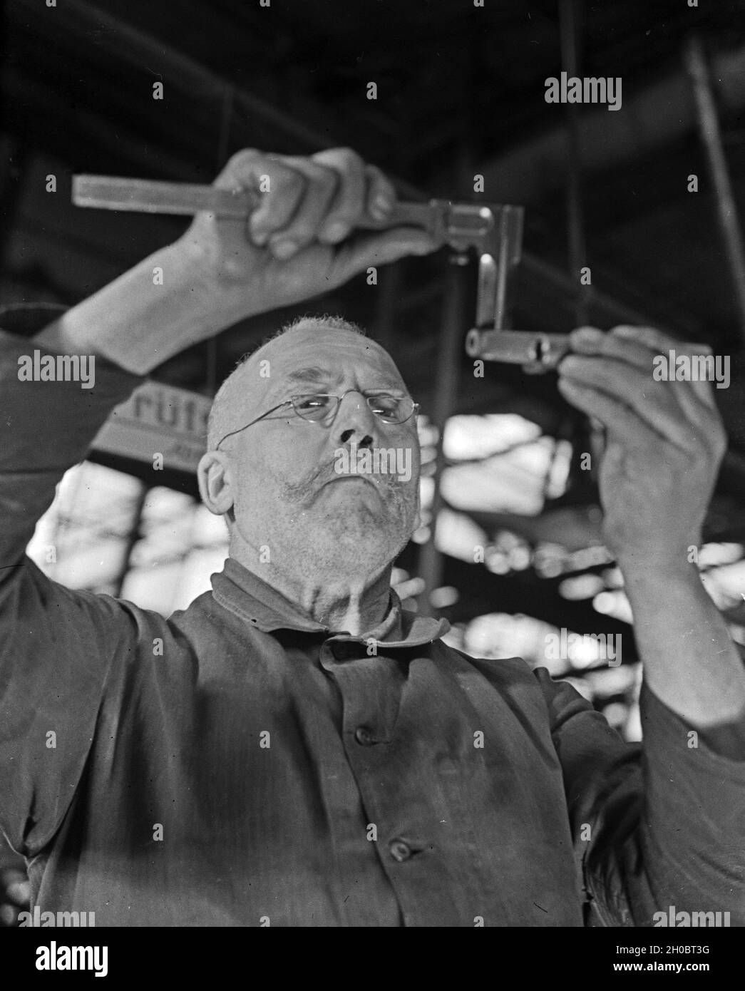 Arbeiter in einer Fabrikhalle bei Mercedes Benz in Stuttgart, Deutschland 1930er Jahre. Arbeiter in einer Werkshalle bei Mercedes Benz in Stuttgart, 1930er Jahre. Stockfoto