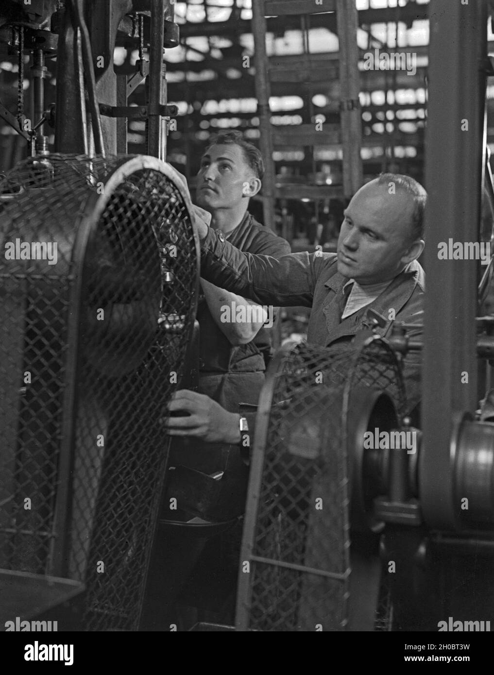 Arbeiter in einer Fabrikhalle bei Mercedes Benz in Stuttgart, Deutschland 1930er Jahre. Arbeiter in einer Werkshalle bei Mercedes Benz in Stuttgart, 1930er Jahre. Stockfoto