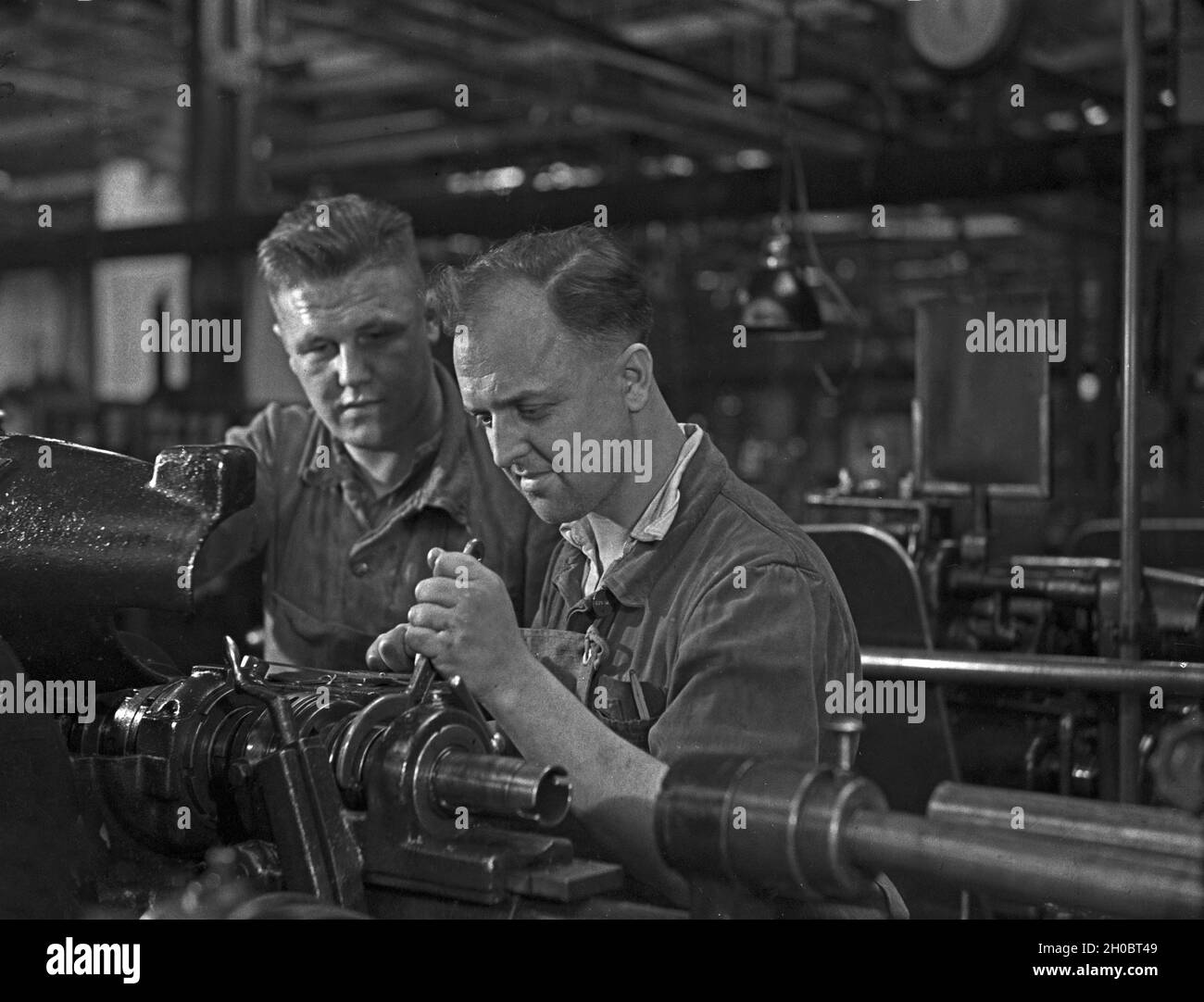 Arbeiter in einer Fabrikhalle bei Mercedes Benz in Stuttgart, Deutschland 1930er Jahre. Arbeiter in einer Werkshalle bei Mercedes Benz in Stuttgart, 1930er Jahre. Stockfoto