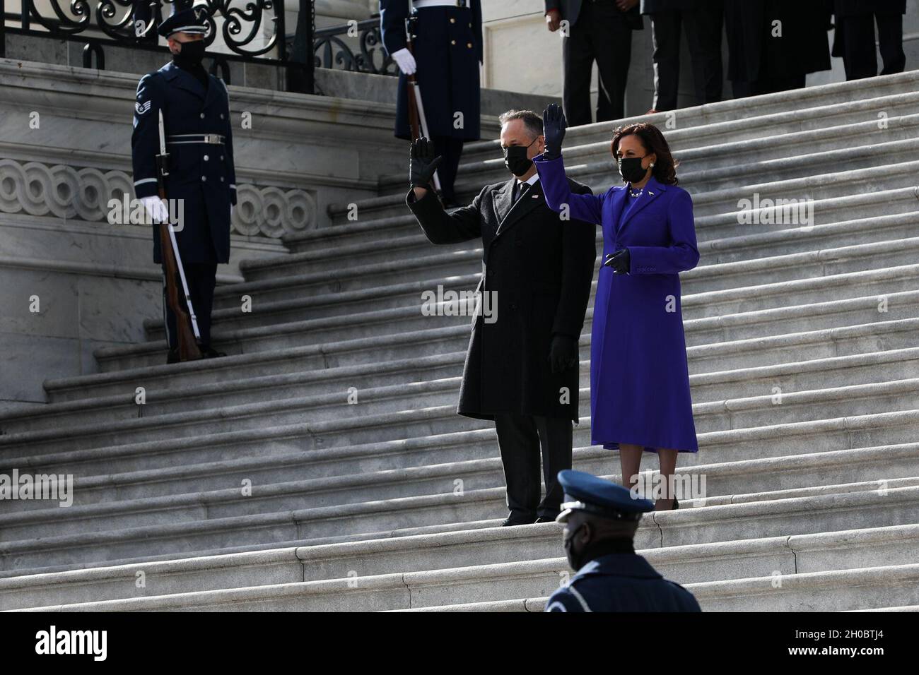 Vizepräsident Kamala D. Harris und ihr Ehemann, Herr Douglas Emhoff, winken dem scheidenden Vizepräsidenten Michael R. Pence und seiner Frau Karen Pence von den Stufen des Capital Building in Washington, D.C., 20. Januar 2021 zu. Eine gemeinsame Dienstabsperrung verliehene den Pence's beim Ausgehen Tribut. Stockfoto