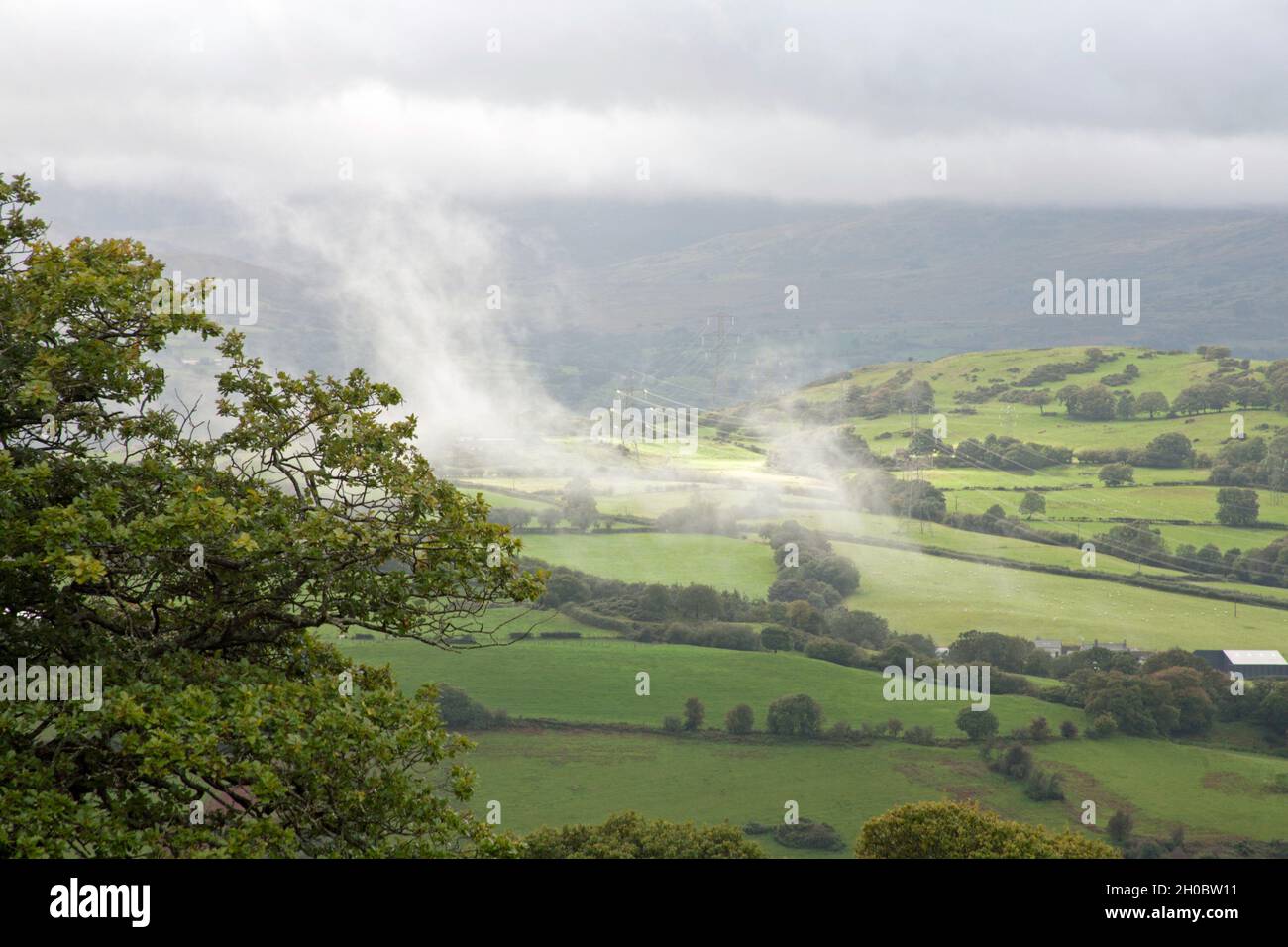 An einem Sommertag in der Nähe des Dorfes Eglwysbach Snowdonia North Wales ziehen Gewitterwolken über die Berge des Conwy Valley Stockfoto