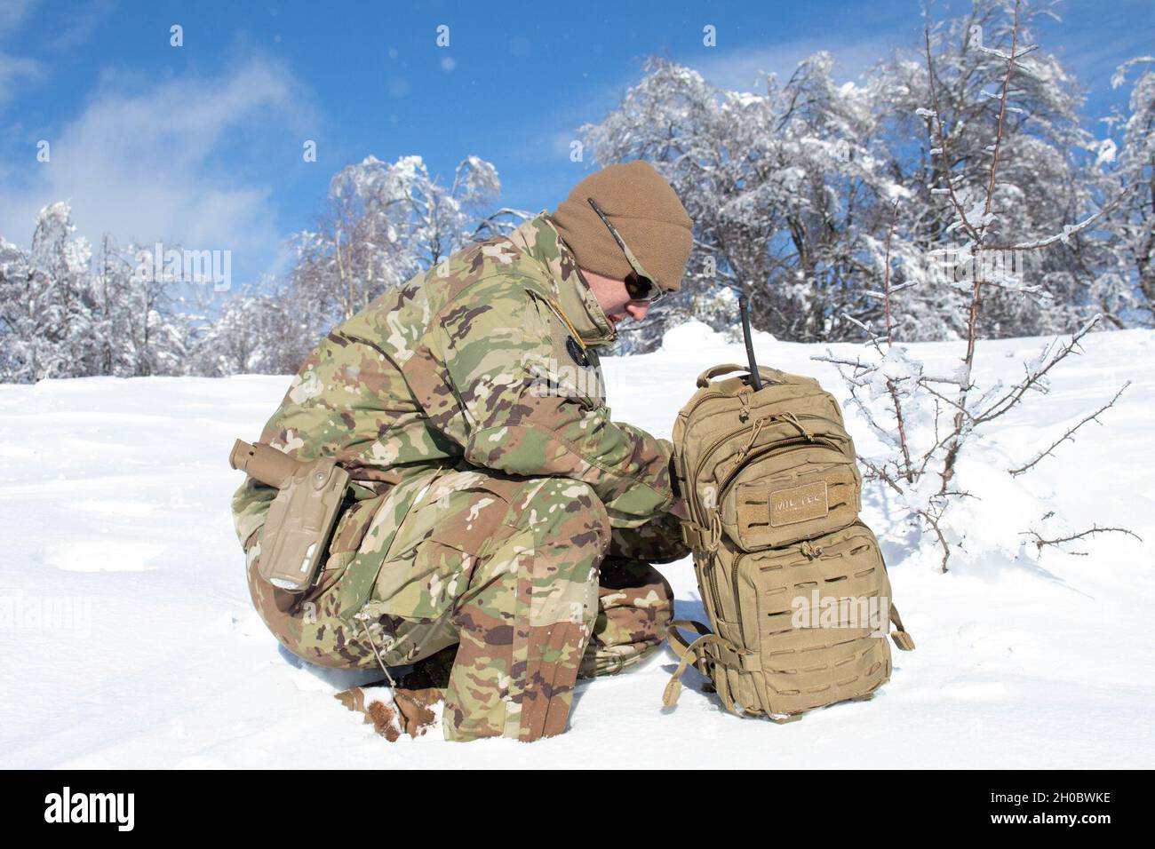 Sgt. Martin Kemp, ein Soldat der Nationalgarde der Iowa-Armee und qualifizierter Pfadfinder, der dem Regionalkommando Ost der Kosovo Force zugewiesen wurde, bestätigt einen Rasterpunkt während einer Hubschrauberlandeplatz-Räumungsmission entlang der administrativen Grenzlinie im Kosovo am 20. Januar 2021. Regelmäßige HLS-Missionen sind für die KFOR unerlässlich, um ein sicheres Umfeld für alle Menschen im Kosovo zu gewährleisten. Der Schnee war zu tief, um den Platz gründlich zu räumen, so dass die Crew zur Basis zurückkehrte und weitere Freiräume durchführen wird, wenn sich die Bedingungen verbessern. Stockfoto