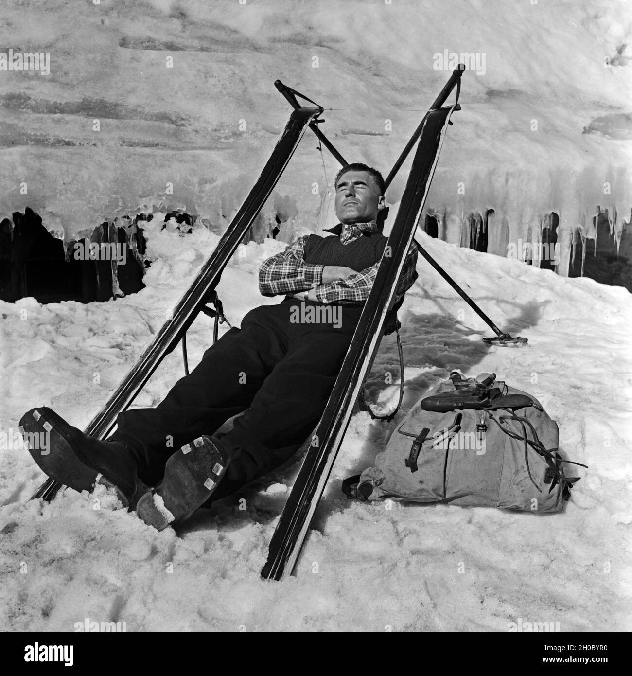 Ein Skiurlauber hat sich aus-Skifahrer einen Sitz gebaut und macht eine Pause, Deutschland 1930er Jahre. Ein Ski touristische erbaut, der Sitz von seinen Skiern und haben jetzt eine Pause, Deutschland 1930. Stockfoto