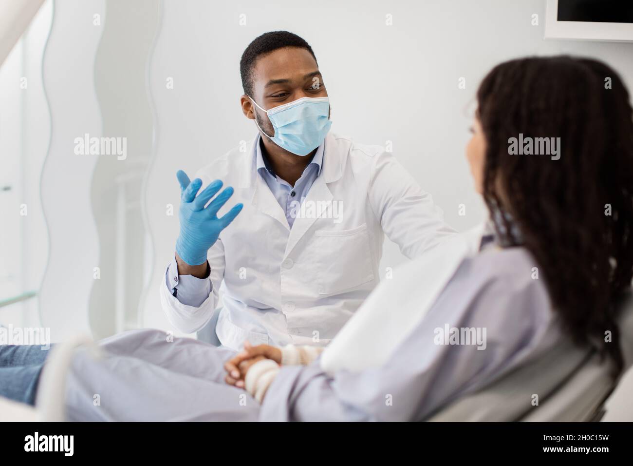 Zahnärztliche Leistungen. Porträt Des Schwarzen Stomatologen Arzt Beratung Weibliche Patientin In Der Klinik Stockfoto