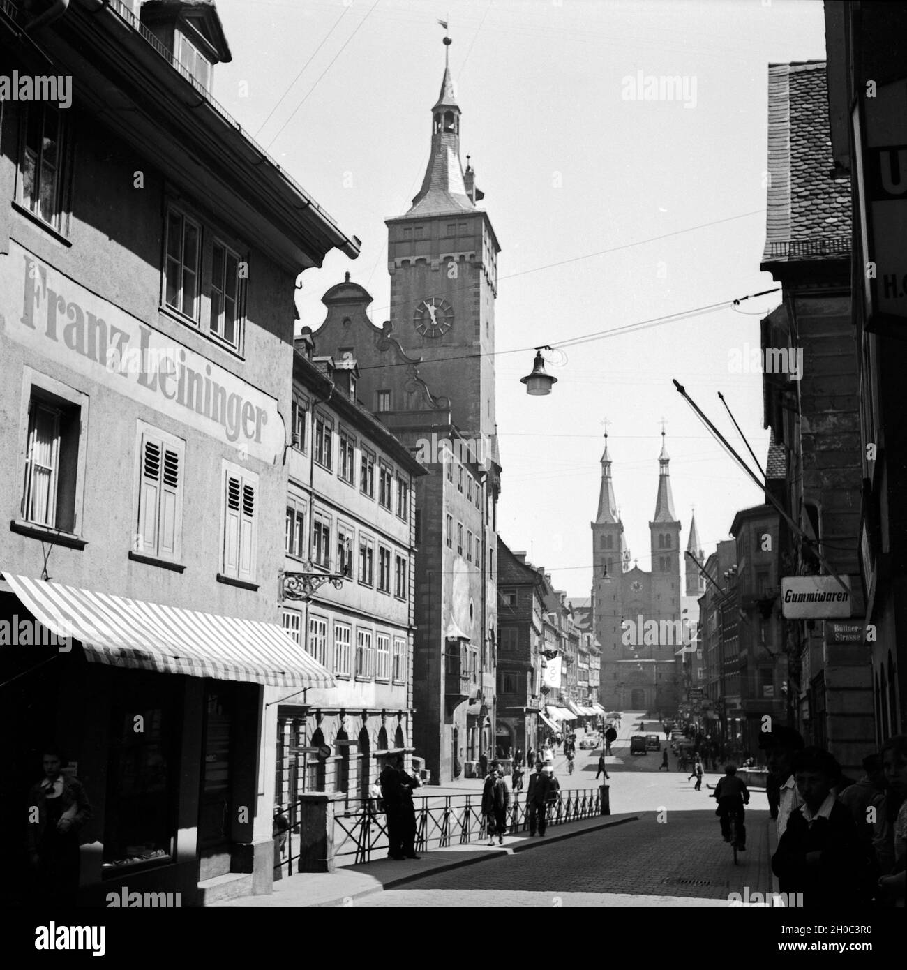 Domstraße in Würzburg mit dem Rathaus und der Westfassade des Domes ist eine belebte Geschäftsstraße, Deutschland 1930er Jahre. Domstrasse Avenue mit Rathaus und der Westfront Wuerzburger Dom, Deutschland 1930. Stockfoto