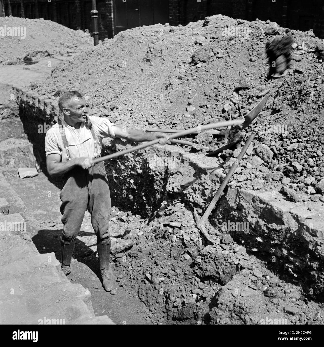 Bauarbeiter gräbt in einer Straße in Wuppertal, Deutschland 1930er Jahre. Bauarbeiter Graben an eine Baustelle in Wuppertal, 1930er Jahre. Stockfoto