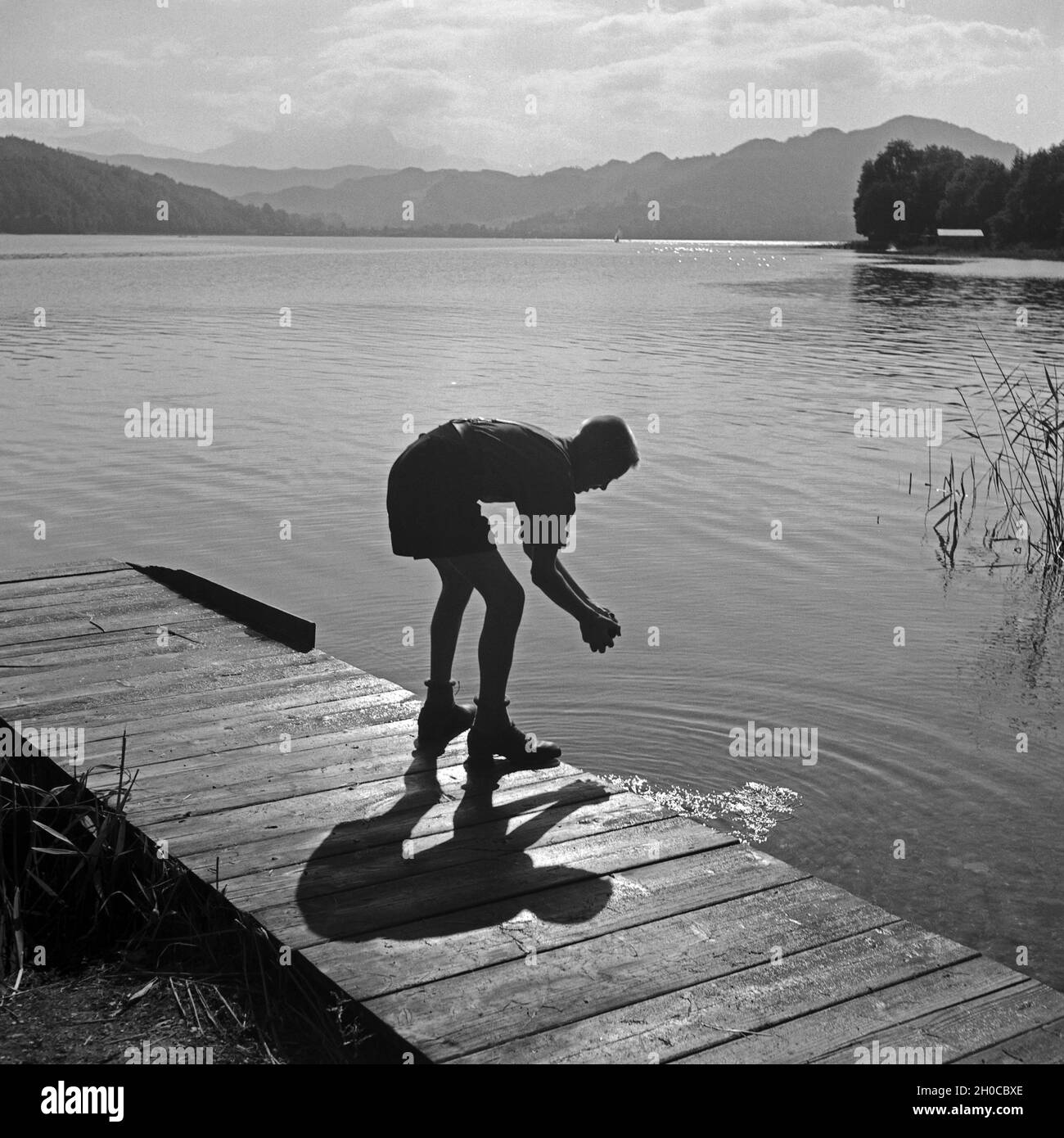 Ein Hitlerjunge Beim Händewaschen in Einem See Nahe Vom Hitlerjugend Lager Österreich 1930er Jahre. Ein Hitler-Jugend, seine Hände zu waschen, auf einem Holzsteg am See in der Nähe von Hitler Jugendcamp, Österreich der 1930er Jahre. Stockfoto