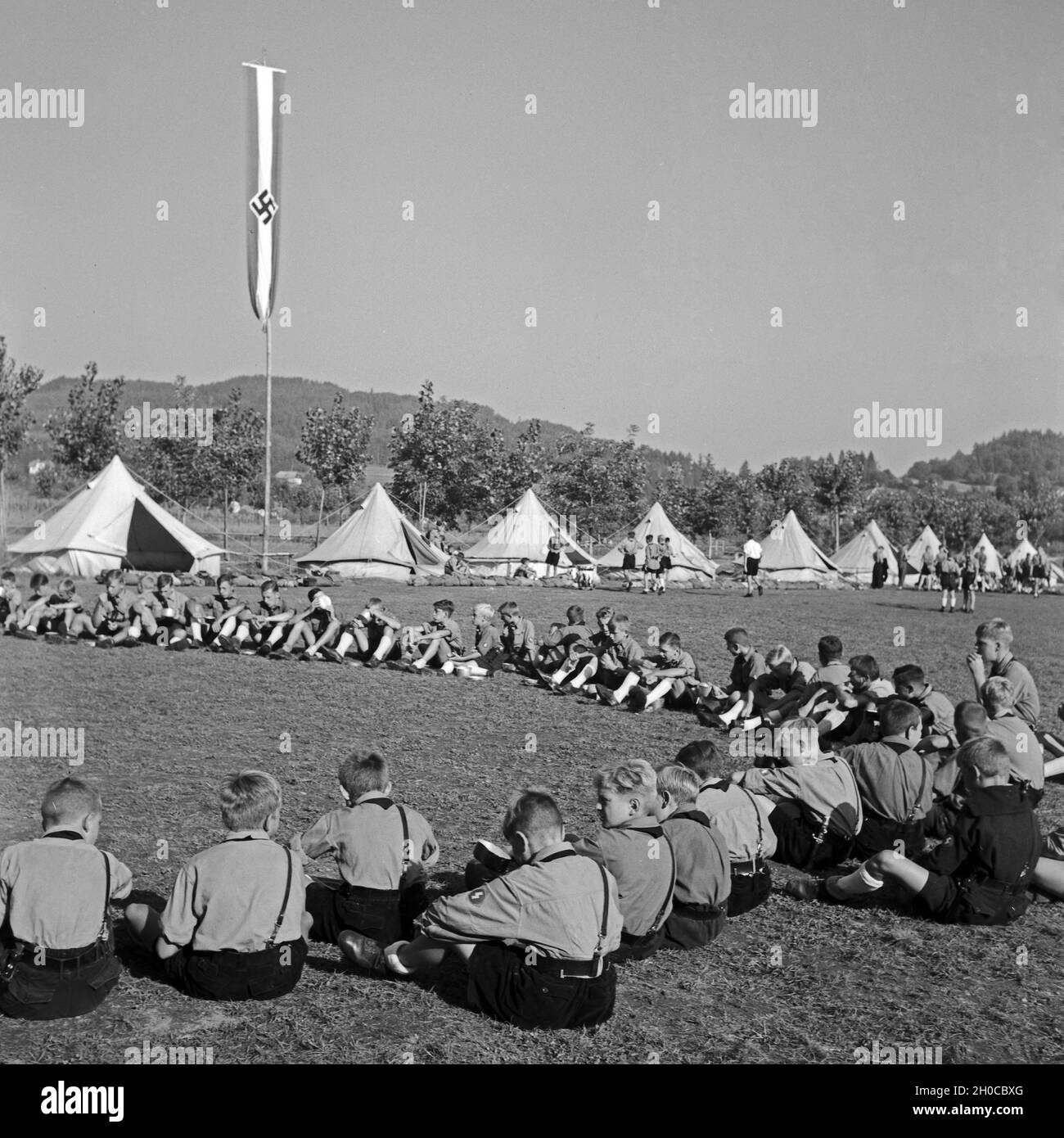 Sitzkreis zur Empfang des Tagesbefehls im Hitlerjugend Lagerbier, Österreich 1930er Jahre. Sitzen und Warten auf die Tagesordnung an Hitler Youth Camp, Österreich 1930. Stockfoto