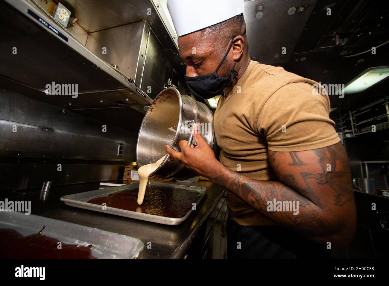 PAZIFISCHER OZEAN (Jan 21, 2021) Culinary Specialist (Submarine) 2nd Class Muhammad Abdul aus Toledo, Ohio, der Goldmannschaft des Ohio-Klasse-U-Bootes USS Ohio (SSGN 726) zugeordnet, kombiniert Zutaten zu einem Marmorkuchen. Ohio führt Überwachungs-, Trainings- und andere kritische Missionen im Einsatzgebiet der 7. US-Flotte durch. Stockfoto