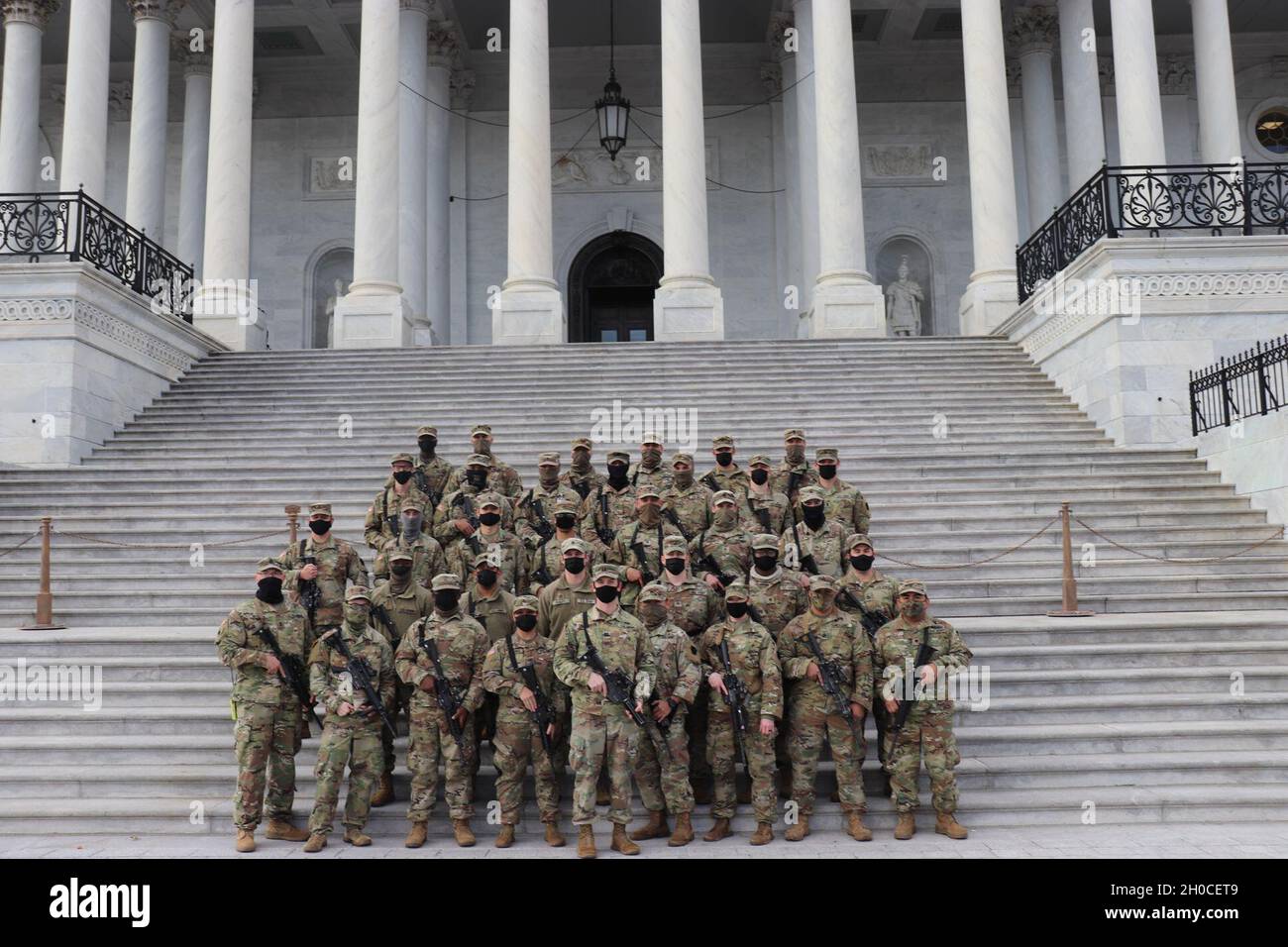 US-Soldaten der Company B, 1. Bataillon, 175. Infanterie-Regiment, Maryland National Guard, posieren für ein Gruppenfoto auf den Stufen des US-Kapitolgebäudes in Washington, D.C., 22. Januar 2021. Mindestens 25,000 Männer und Frauen der Nationalgarde wurden autorisiert, Sicherheits-, Kommunikations- und Logistikmissionen zur Unterstützung der Bundes- und Bezirksbehörden durchzuführen, die vor und während der 59. Amtseinführung des Präsidenten geführt wurden. Stockfoto