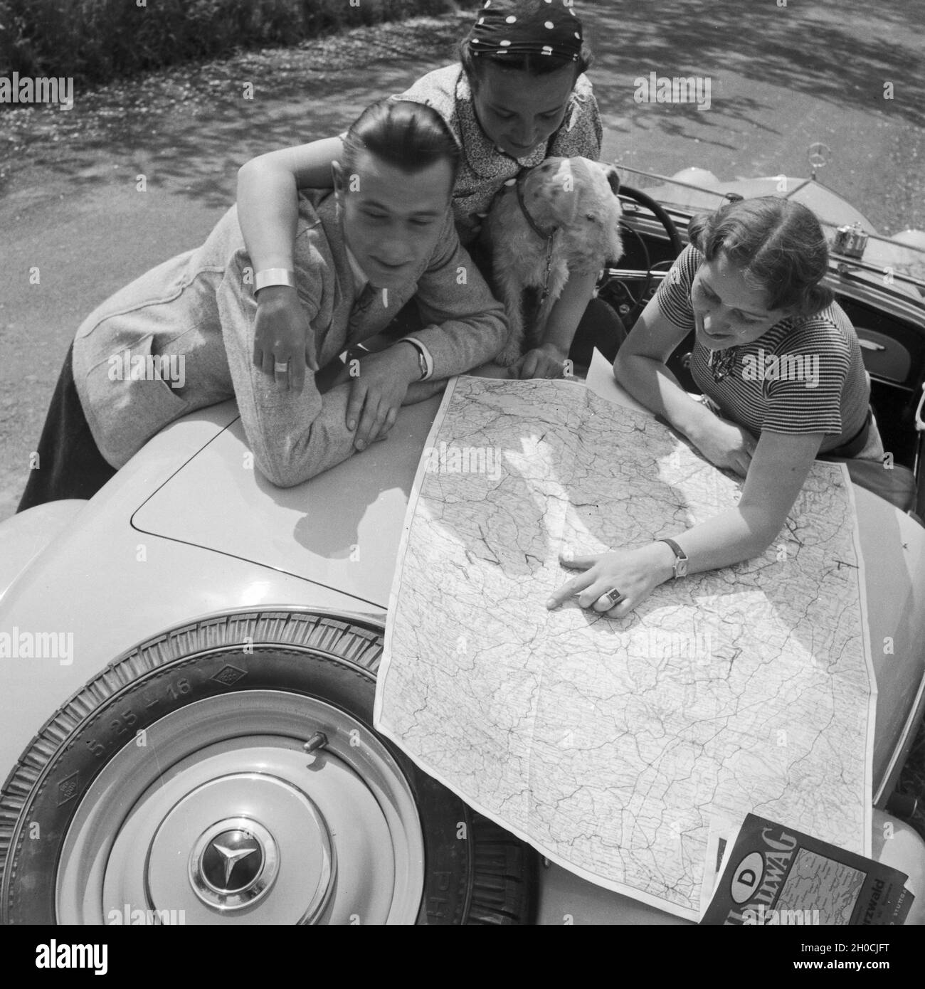 Zwei Frauen, ein Mann und eine Hund eine 1963 Mercedes Benz Cabrio, Deutschland 1930er Jahre. Zwei Frauen mit Hund und Mann bin an ihrem Mercedes Benz Cabrio, Deutschland 1930. Stockfoto