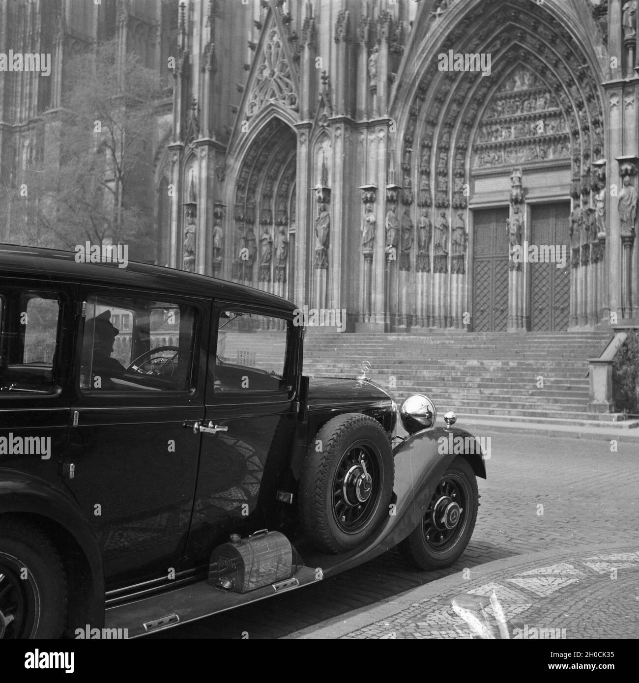 Pullman Limousine von Mercedes Benz vor dem Portal am Hohen Dom zu Köln, Deutschland 1930er Jahre. Pullman cab vor dem Haupteingang der Kathedrale in Köln, Deutschland 1930. Stockfoto