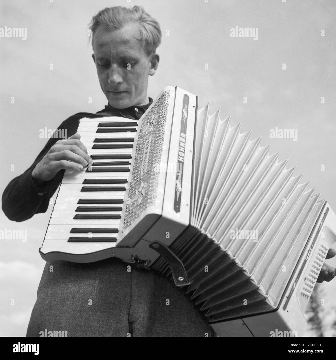 Ein junger Mann der Fotograf Karl Heinrich Lämmel spielt Akkordeon, Deutschland 1930er Jahre. Ein junger Mann der Fotograf Karl Heinrich Lämmel spielt Akkordeon, Deutschland 1930er Jahre. Stockfoto