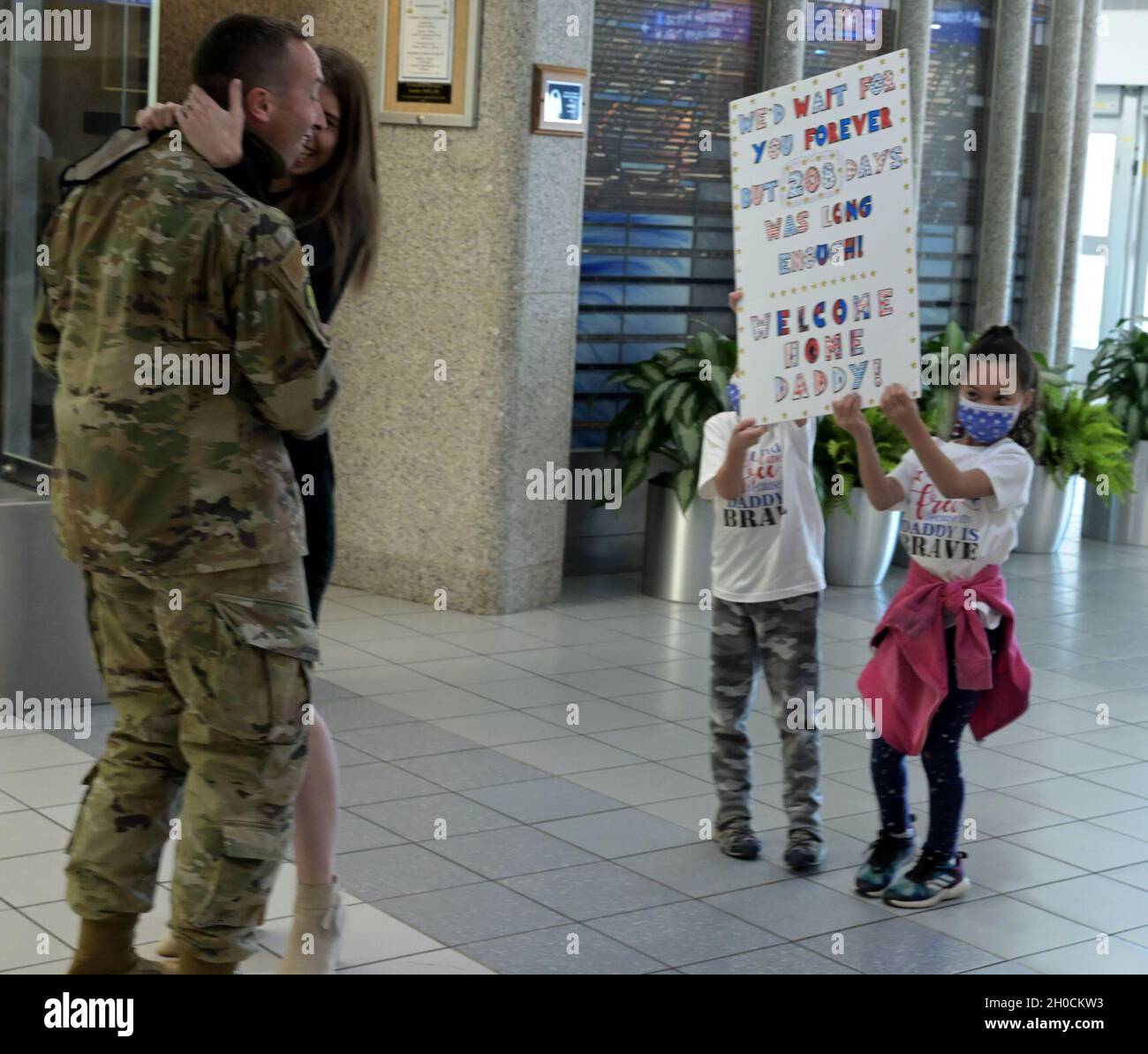 Senior Master Sgt. Bryan Schoenecke wird am Lambert International Airport in St. Louis, Mo., 23. Januar 2021, von seiner Frau Samantha und ihren Kindern zu Hause begrüßt. Das Mitglied der Illinois Air National Guard absolvierte einen sechsmonatigen Einsatz nach Afrika. Stockfoto