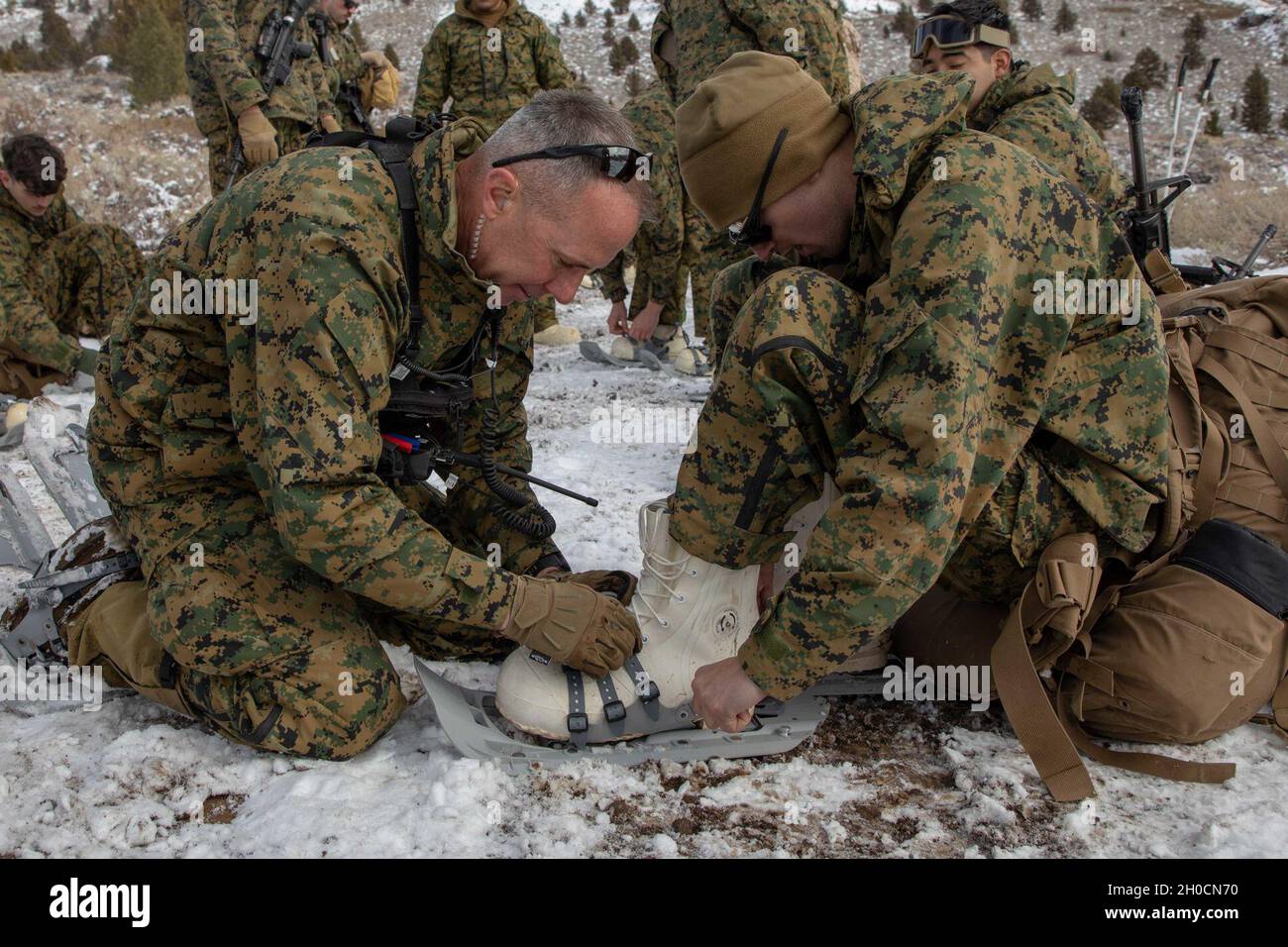US Marine Corps Col. Daniel Wittnam, Kommandant des Marine Corps Mountain Warfare Training Center (MCMWTC), passt während einer Wanderung zu Grouse Meadows im MCMWTC, Bridgeport, Kalifornien, während der Mountain Training Exercise 2-21, 24. Januar 2021, die Schneeschuhe eines Marine an. Marineinfanteristen und Segler trainieren am MCMWTC, um sich auf die Strapazen des Betriebs bei rauen Wetterbedingungen, bergigen Böden und erhöhten Höhenlagen vorzubereiten. Stockfoto