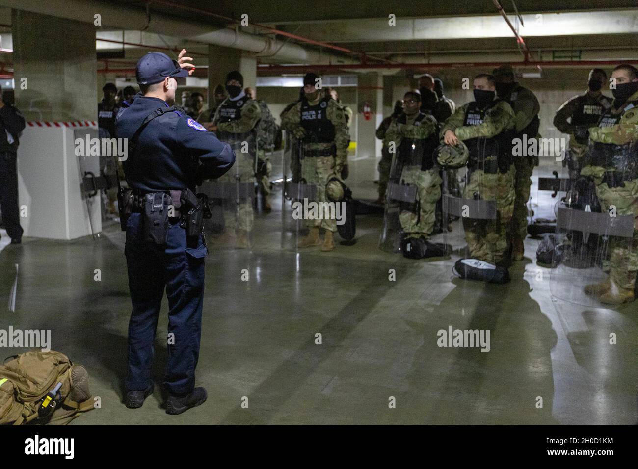 Shauni Kerkhoff, Polizeibeamter des US-Kapitols, zeigt Soldaten des 115. Militärpolizei-Bataillons der Maryland Army National Guard, Salisbury, Maryland, während einer gemeinsamen Trainingsveranstaltung in Washington D.C. am 27. Januar 2021 eine Gummikugel. Die MDNG erhielt von der USCP eine Schulung zum Kennenlernen weniger tödlicher Waffen und ziviler Unruhen. Die Nationalgarde wurde aufgefordert, die Strafverfolgungsbehörden der Bundesstaaten bis Mitte März mit Sicherheit, Kommunikation, medizinischer Evakuierung, Logistik und Sicherheitsunterstützung für staatliche, Bezirks- und Bundesbehörden zu unterstützen. Stockfoto