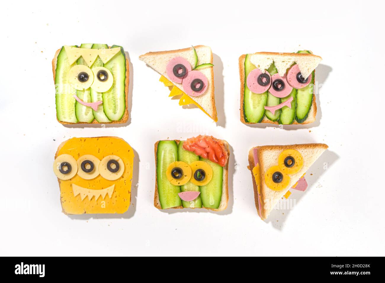 Verschiedene lustige Monster Halloween Sandwiches. Set Sortiment kreative Frühstück Snack Toast mit Käse, Halloween Kinder Party Essen, Draufsicht Stockfoto