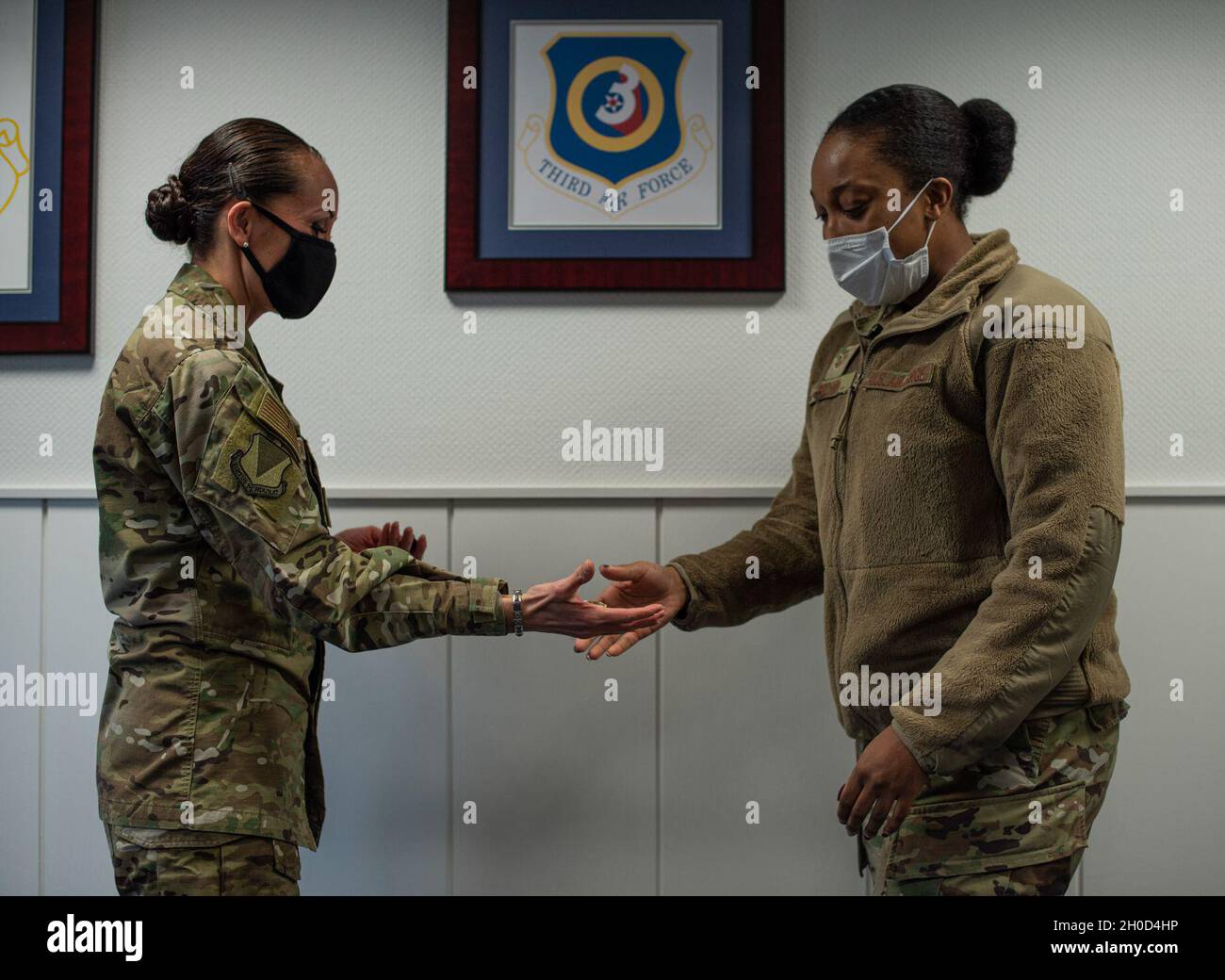 US Air Force Tech. Sgt. Tamara Brown, Leiterin der Abteilung für Patientenverwaltung des 86. Medizinischen Unterstützungsgeschwaders, erhält eine Münze vom Kommandochef des 86. Luftlift-Flügels, Master Sgt. Hope Skibitsky, auf dem Luftwaffenstützpunkt Ramstein, Deutschland, 28. Januar 2021. Brown wurde für ihre Führungsstärke und ihr Engagement für ihren Job als Luftlifter der Woche anerkannt. Stockfoto