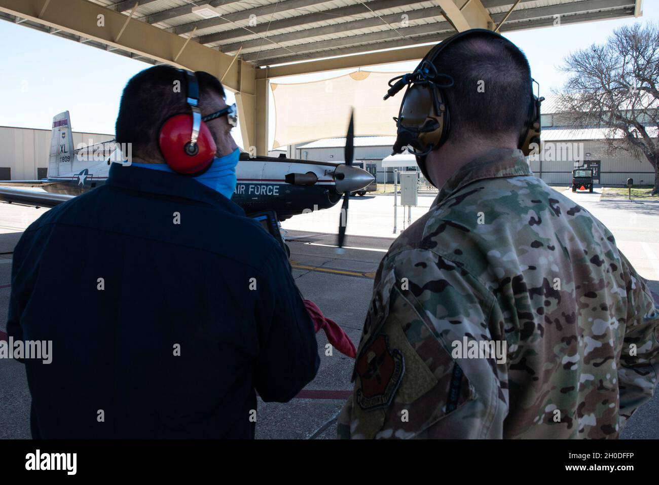 Col. Craig Prather, 47. Kommandant des Flying Training Wings, tritt am 01. Februar 2021 in Laughlin Air Force Base, Texas, mit dem Wartungschef George Hernandez auf der Fluglinie zusammen, um über die T-6A Texan II zu schauen. Dieser Besuch war Teil des Eintauchens von Col. Prather mit den Wartungsteams an der Fluglinie. Stockfoto