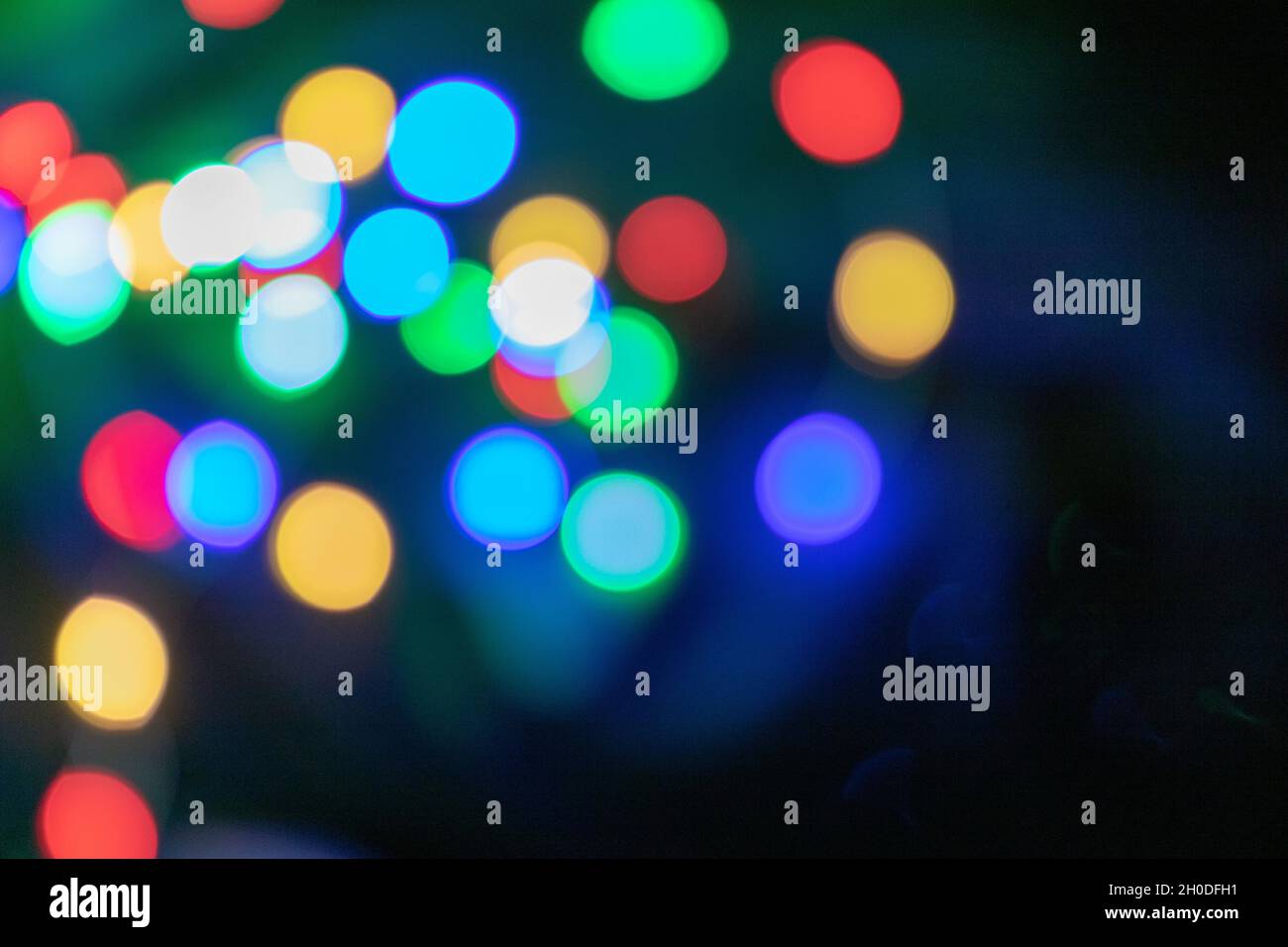 Bunte Bokeh-Lichter in Blau, Grün, Rot und Gelb auf dunklem Hintergrund Stockfoto