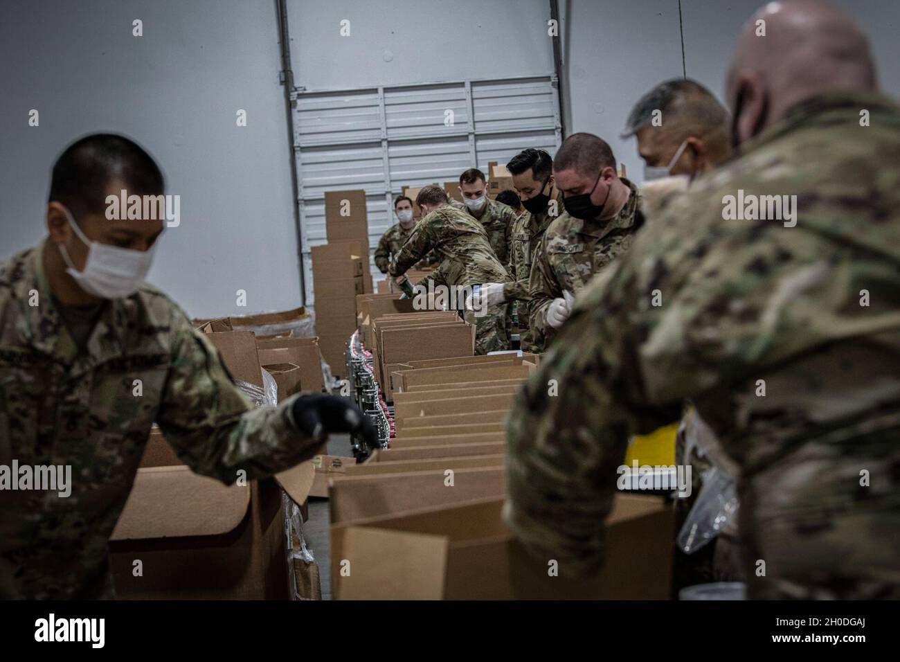 Soldaten der Nationalgarde der Washington Army beladen Kartons mit unvergänglichen Lebensmitteln 2. Februar 2021, Kent Wash. Dieses Lager wird an die Lebensmittelbanken der Gemeinde im Westen Washingtons verteilt. Bei diesen Soldaten handelt es sich um Einheimische aus Washington, die aktiviert wurden, um Gemeinden mit hohem Risiko bei der Bekämpfung der durch COVID-19 verursachten Hungerkrise zu helfen. Stockfoto