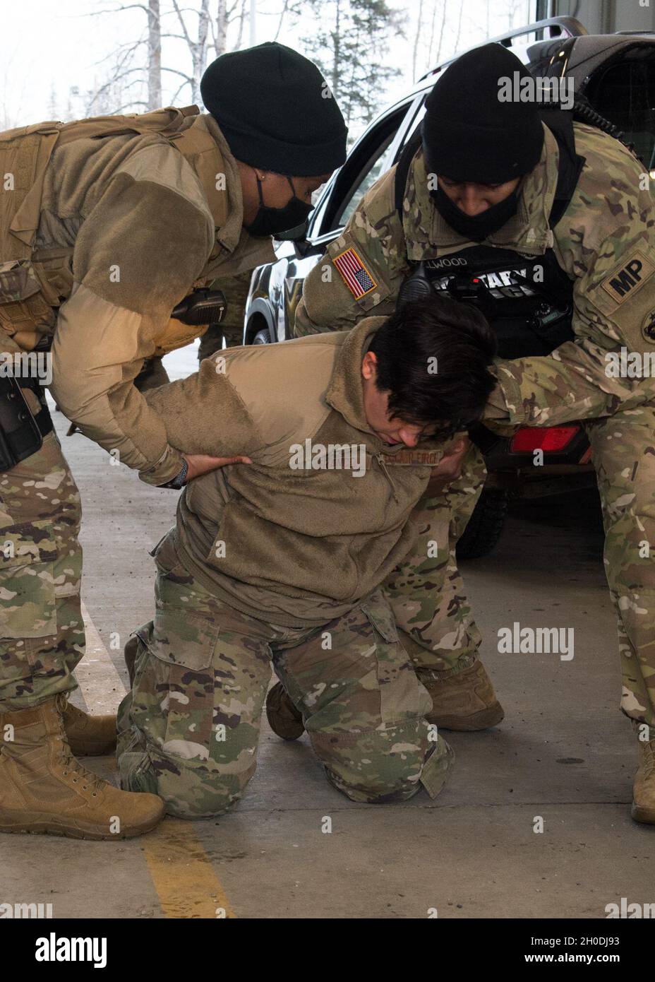 SPC der US-Armee. Derian Callwood, rechts, ein Patrolman der 673 Sicherheitskräfte, der der 545. Militärpolizei und der US Air Force Tech zugeordnet ist. Sgt. Jasmine Scott, links, der 673d SFS Kodiak Flight Flugfeldwebel, simuliert die Festnahme der Senior Airman der US Air Force Lilia Franco, einer 673d SFS Operations Support Specialist, als Teil einer DUI-Verkehrsstoppdemonstration während eines Eintauchens mit dem 673d SFS auf der Joint Base Elmendorf-Richardson, Alaska, 2. Februar 2021. Die Tour machte die Basisleitung mit dem 673d SFS und seiner Rolle bei der Aufrechterhaltung der Sicherheit des JBER-Commu vertraut Stockfoto