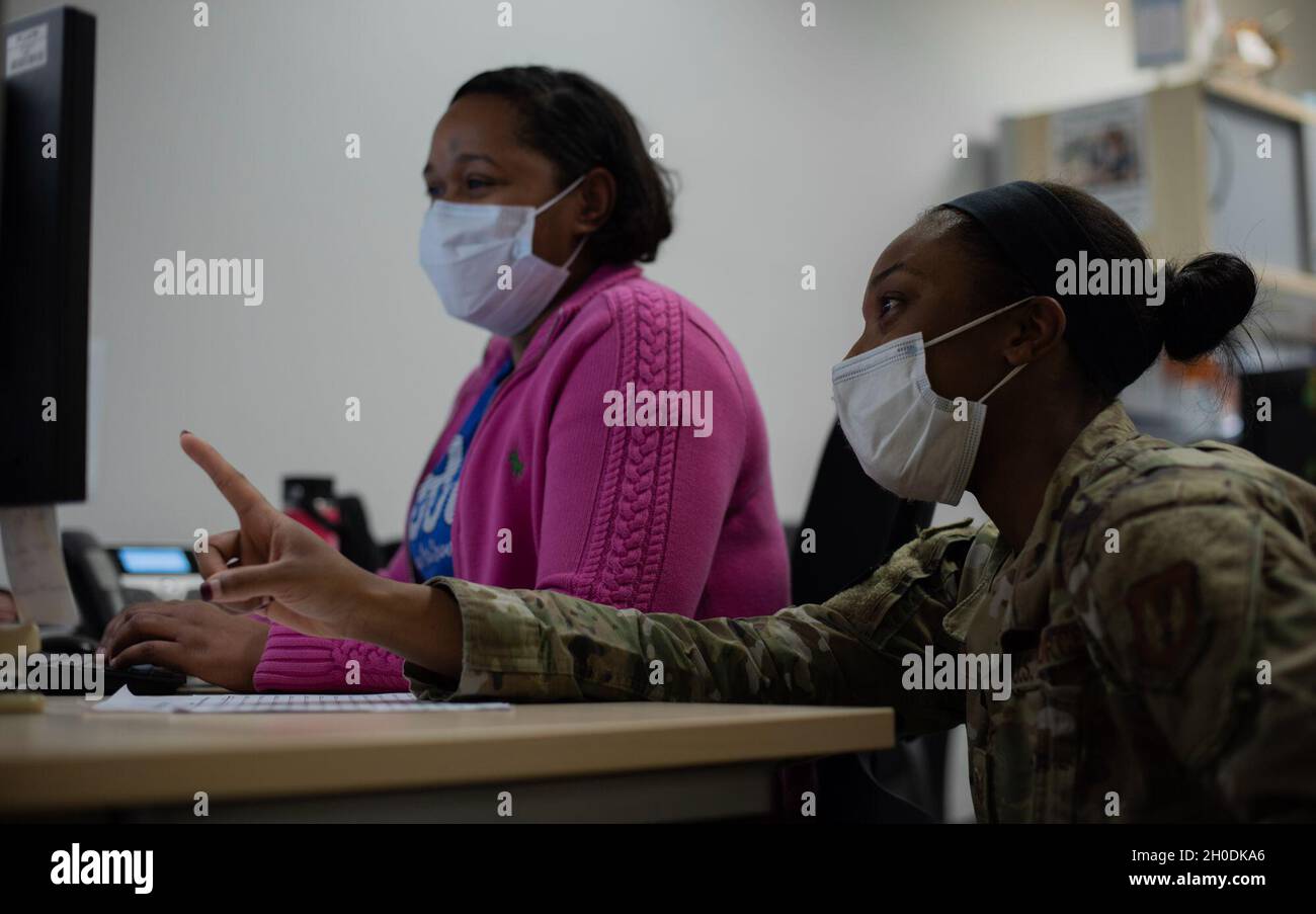 US Air Force Tech. Sgt. Tamara Brown, Leiterin der Abteilung für Patientenverwaltung des 86. Medizinischen Unterstützungsgeschwaders, spricht mit Robin Robinson, 86. MDSS-Assistentin für medizinische Unterstützung, auf dem Luftwaffenstützpunkt Ramstein, Deutschland, 3. Februar 2021. Brown und Robinson überprüften eine Liste von Patienten, die auf COVID-19 negativ getestet wurden. Stockfoto